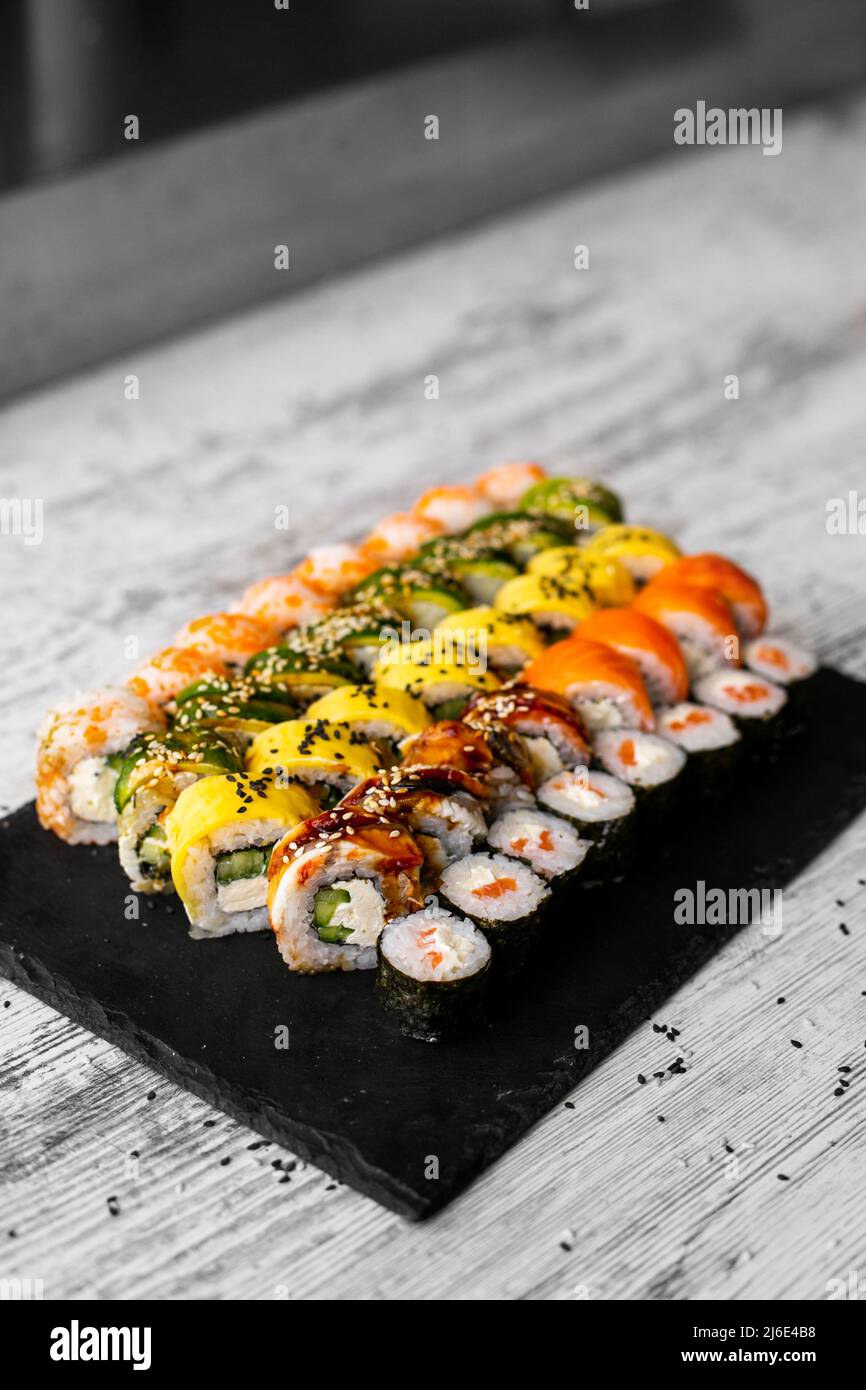 Sushi Set Nigiri und Sushi-Rollen auf schwarzem Stein Schieferteller Board. Platz für tex. instagram Geschichten Stockfoto