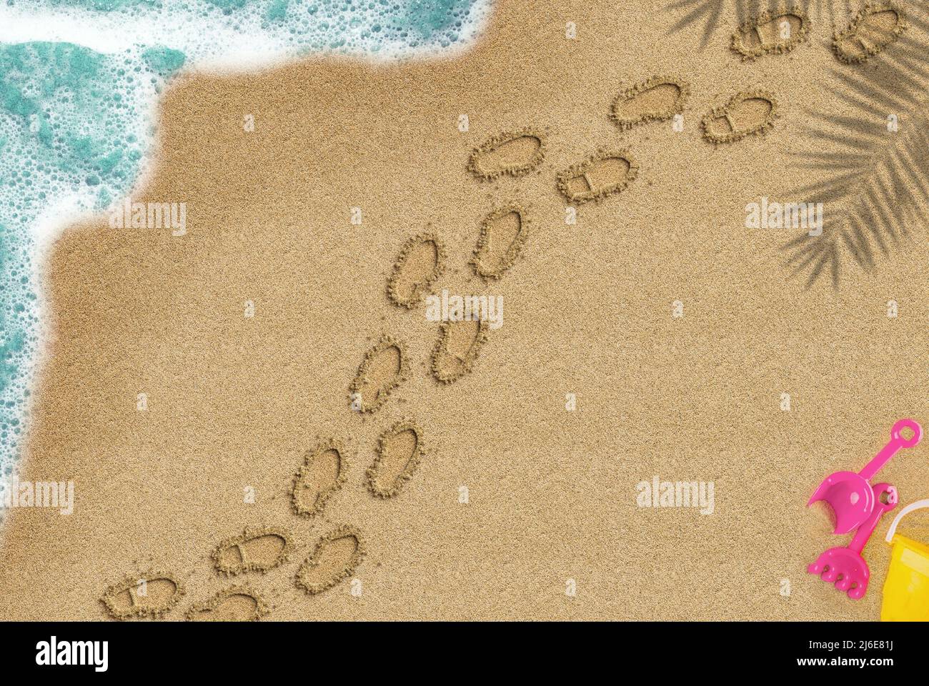 Fußabdruck am Sandstrand, Spaziergang auf Sand Konzept, Palmschatten und Meereswelle und Spielzeug Zusammensetzung, Summer Times Trip Idee, Draufsicht auf Sandstrand Stockfoto