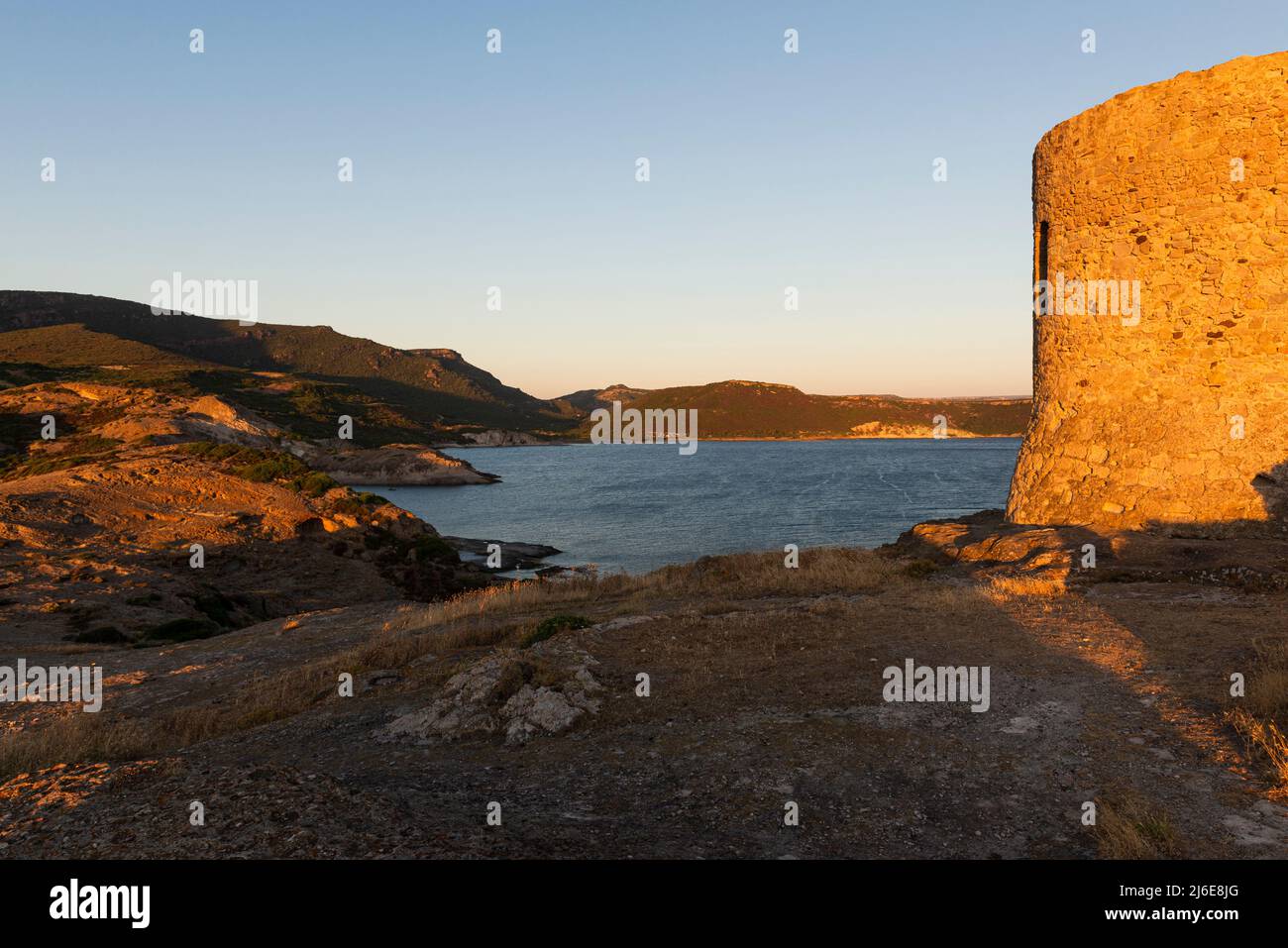 Ruinen des alten Küstenwachturms Torre Argentina auf einem Felsen oberhalb der Westküste Sardiniens bei S'Abba Druche bei Sonnenuntergang, Planargia, Italien Stockfoto