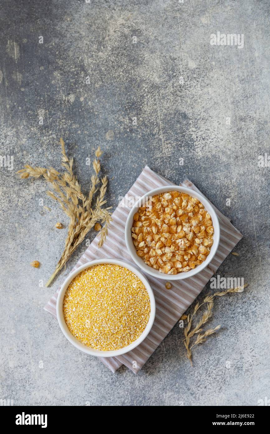 Essen und Backen glutenfreier Proteinbestandteil Сorn Mehl gesunden und rohen Mais über grauen Steintisch. Draufsicht flach liegend. Speicherplatz kopieren. Stockfoto