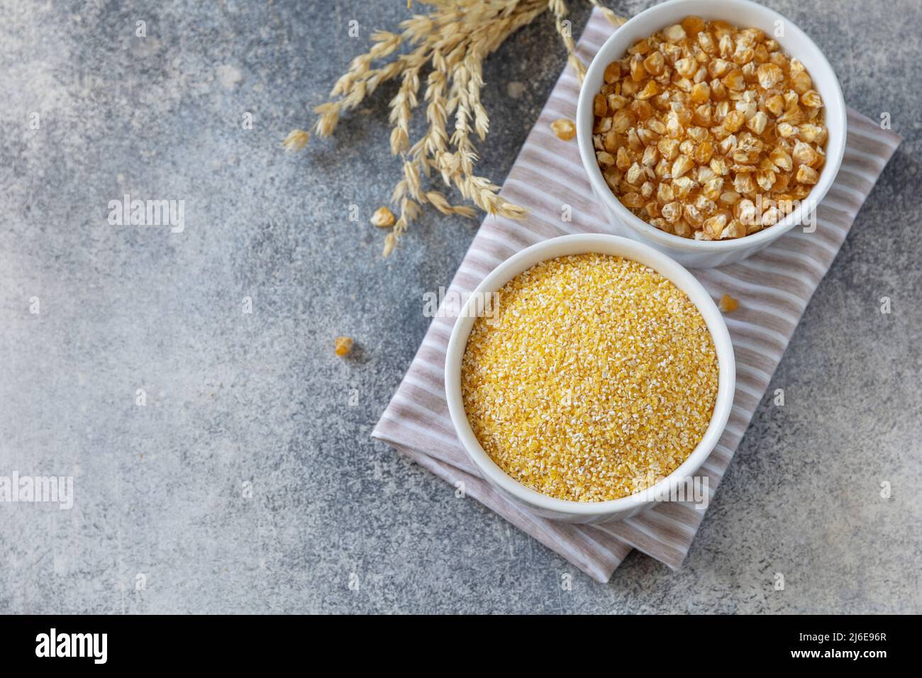 Essen und Backen glutenfreier Proteinbestandteil Сorn Mehl gesunden und rohen Mais über grauen Steintisch. Draufsicht flach liegend. Speicherplatz kopieren. Stockfoto