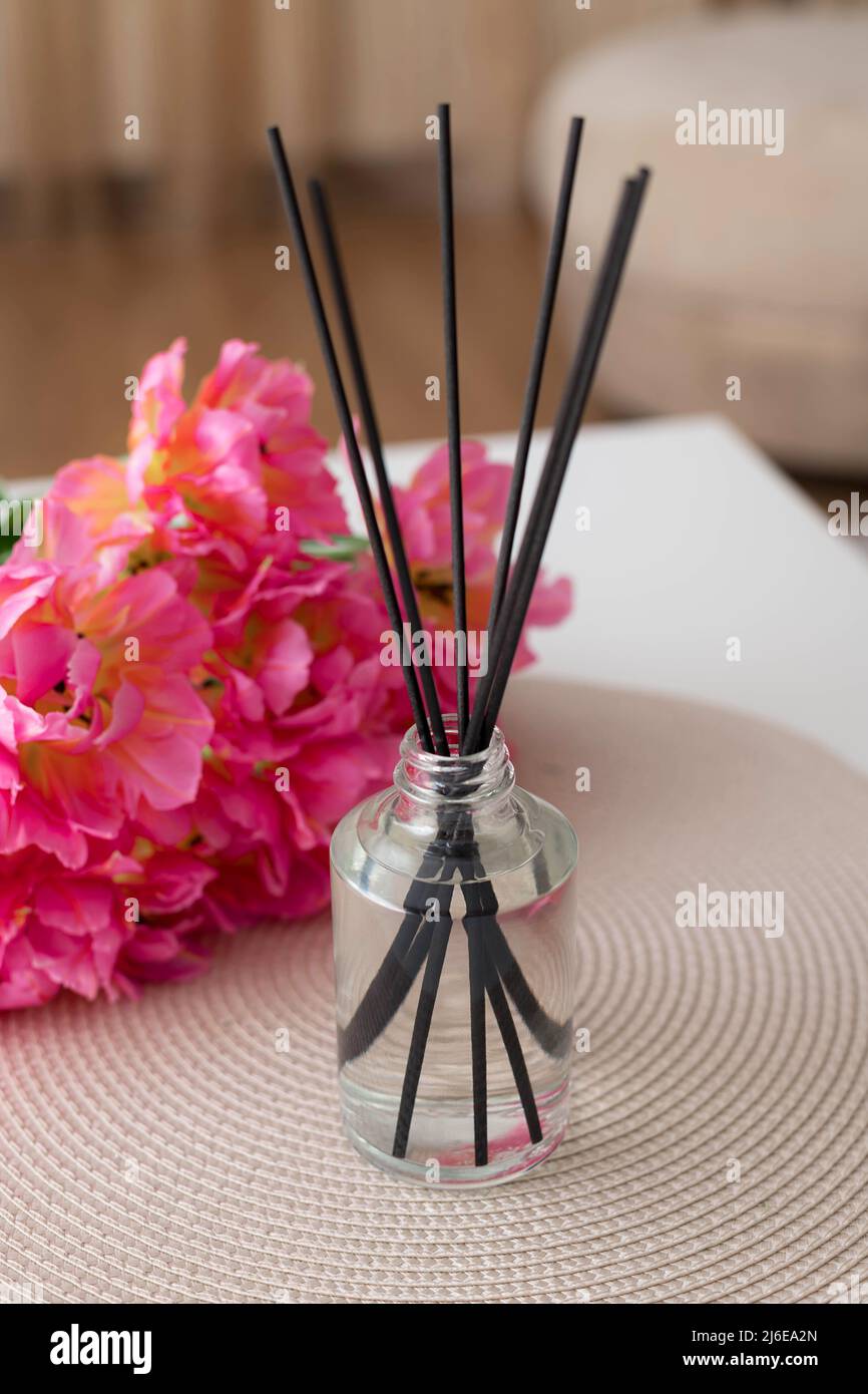 Aroma Schilfdiffusor und schöne Blumen auf weißem Tisch zu Hause Stockfoto