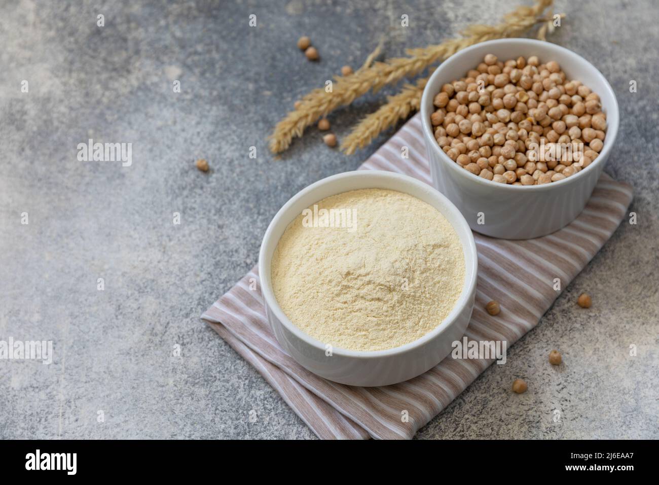 Lebensmittel und Backen glutenfreie Protein-Zutat. Kichererbsenmehl gesunde und rohe Kichererbsenmehl über dem Tisch aus grauem Stein. Speicherplatz kopieren. Stockfoto