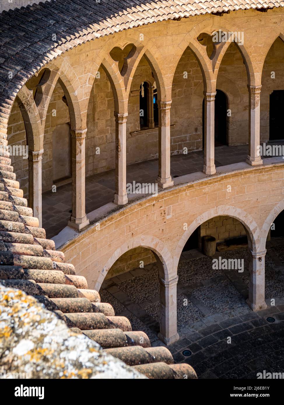 Fotografie der Kolonnade im romanischen Stil im Erdgeschoss und der gotischen Arkade im ersten Stock vom Dach des Castell de Bellver Stockfoto