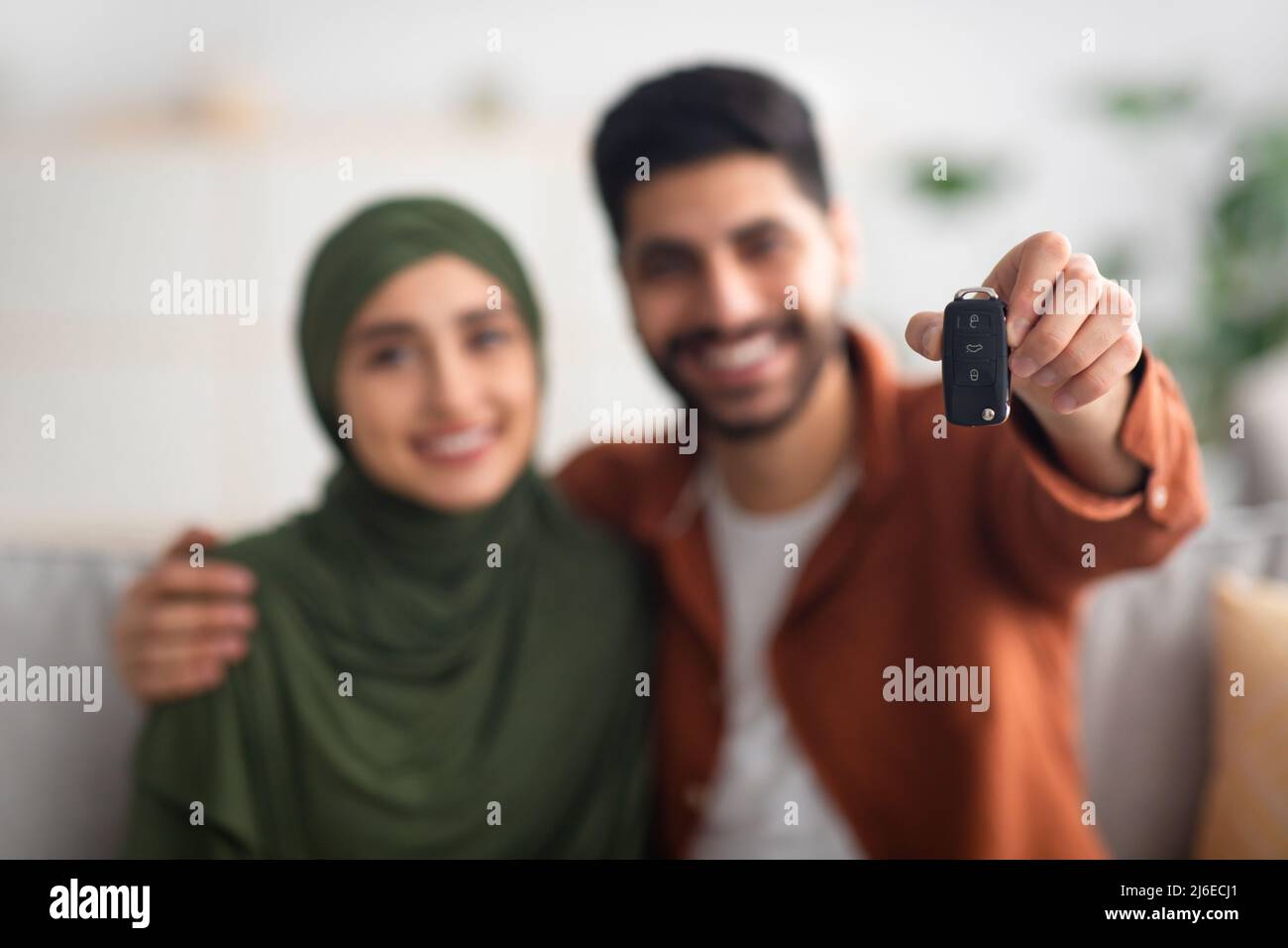 Glückliches Nahöstliches Paar, Das Automobilschlüssel Zur Kamera Im Innen Zeigt Stockfoto