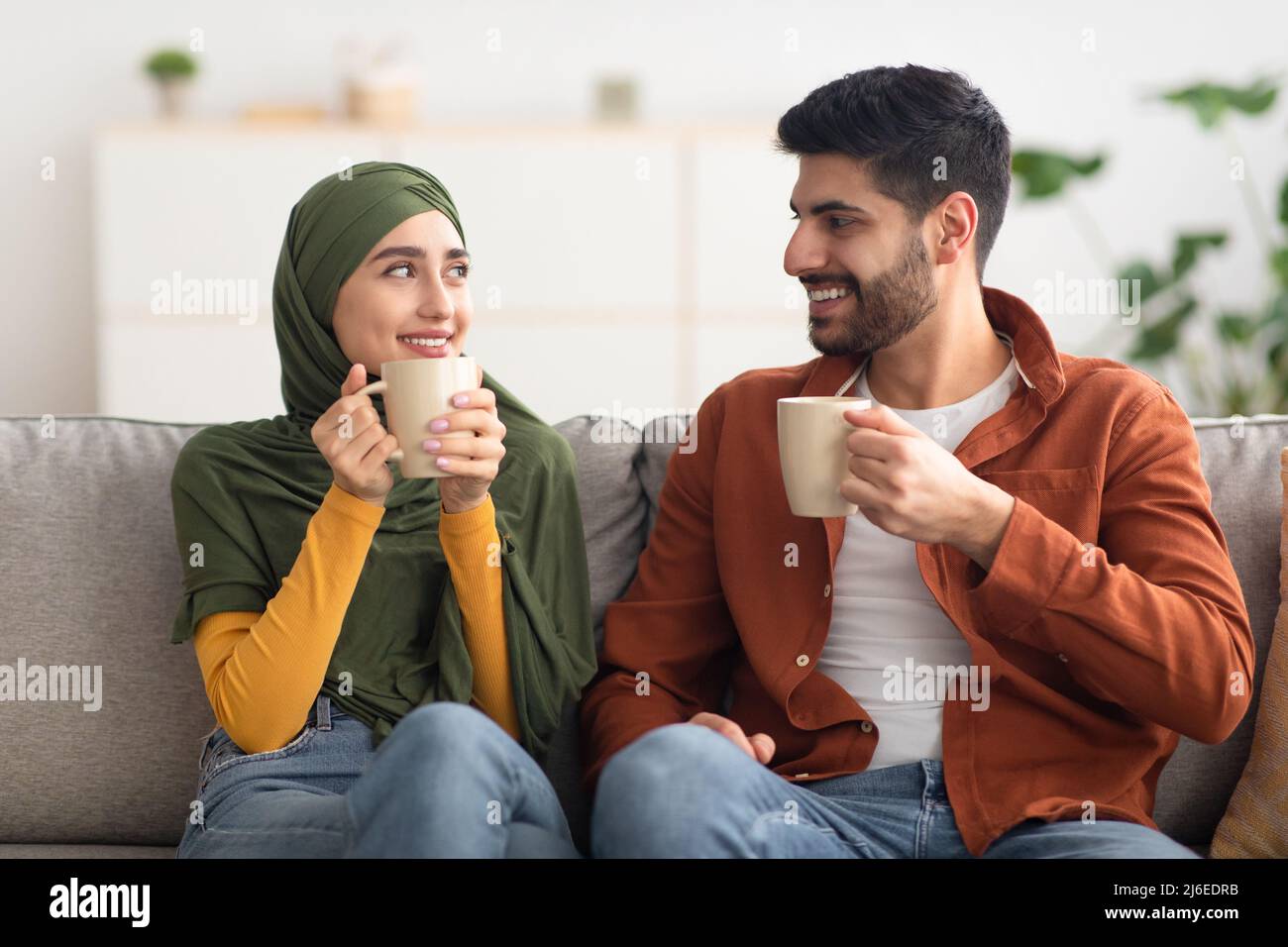 Glückliches Nahöstliches Paar, Das Zu Hause Kaffee Hält Stockfoto
