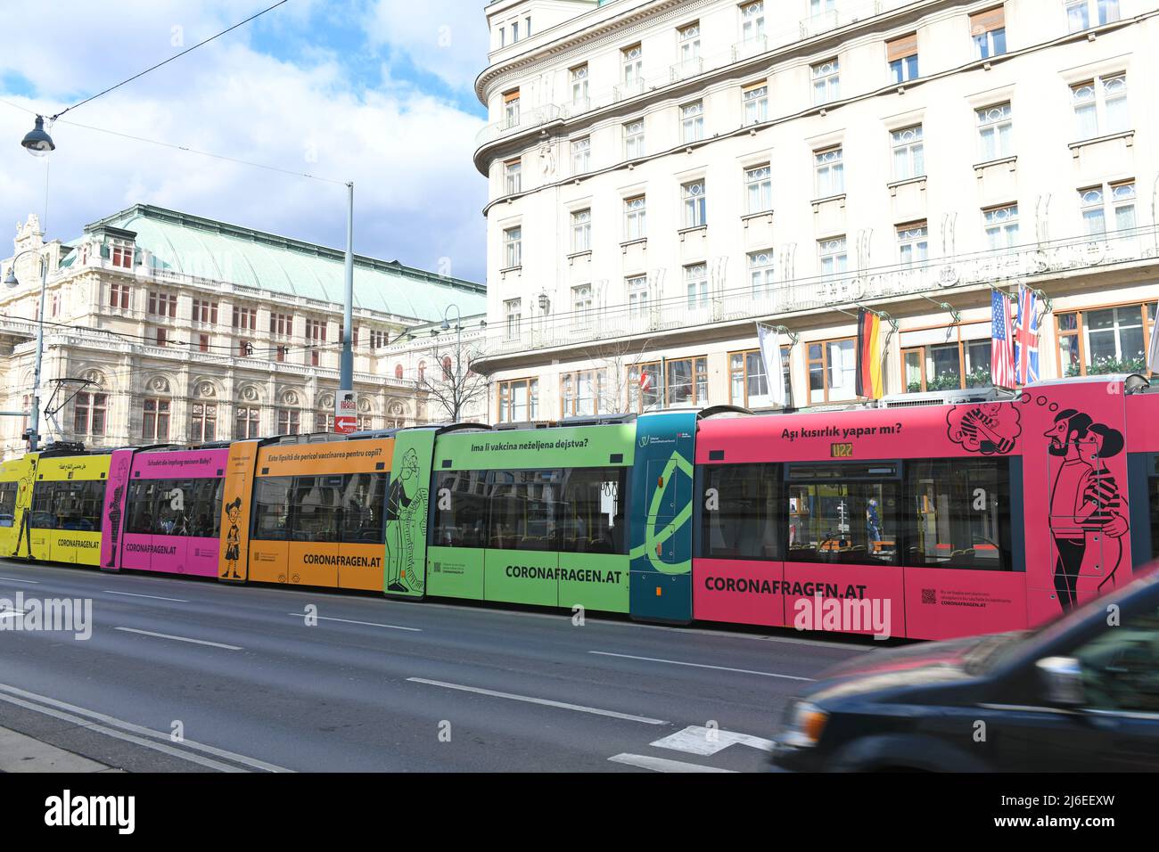 Bunte Straßenbahn in Wien mit mehrsprachiger Schrift zu Coronafragen, Österreich - Bunte Straßenbahn in Wien mit mehrsprachiger Inschrift auf Corona Stockfoto