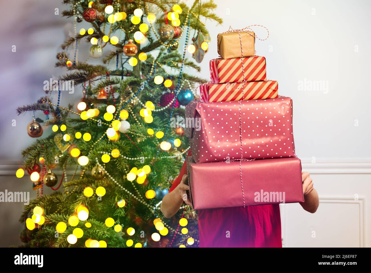 Junge hält große Stapel von Neujahrsgeschenken bedeckt Stockfoto
