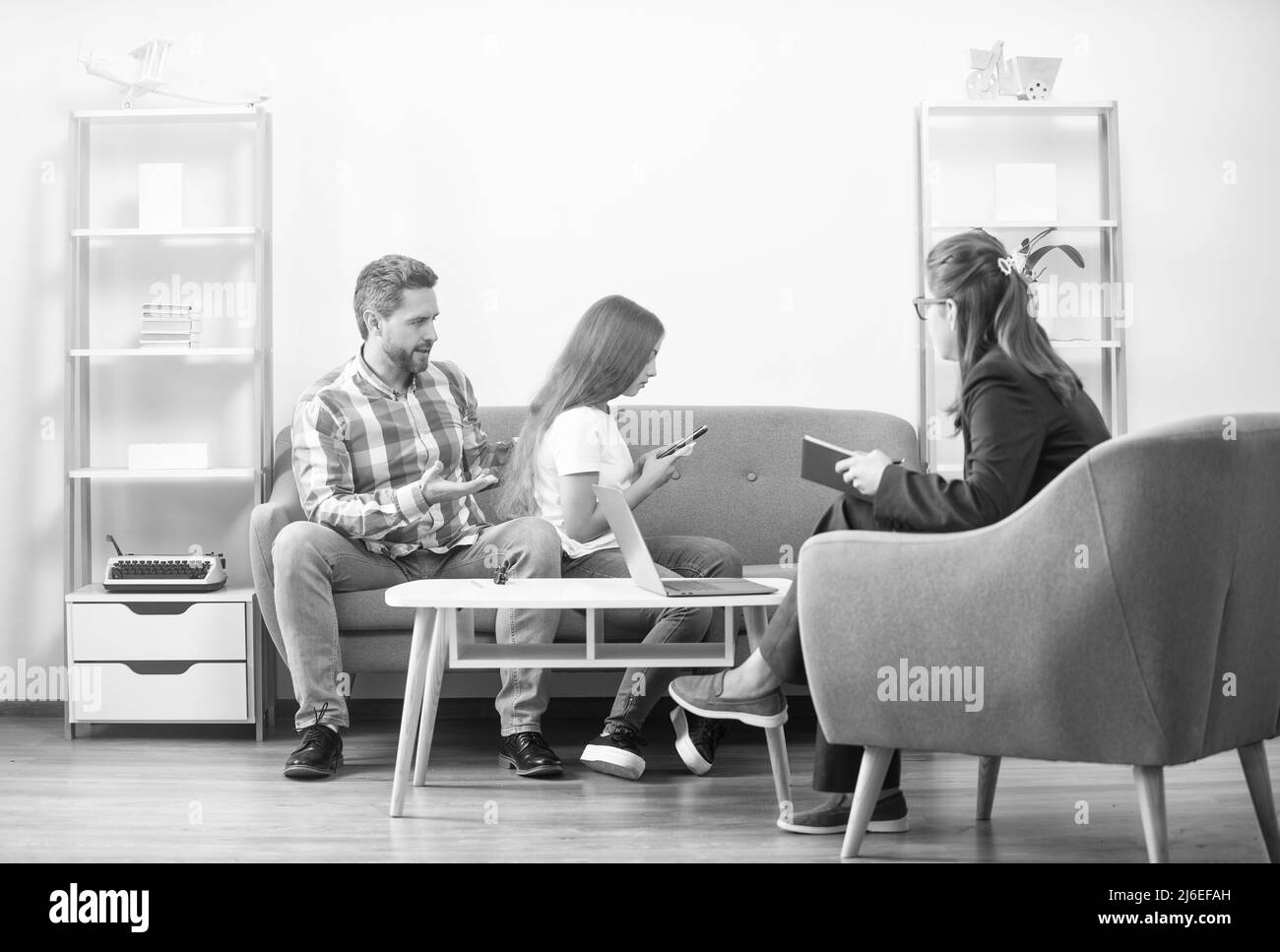 Elternschaft und Vaterschaft. Kind und Vater sprechen mit Sozialarbeitern. Zwischenmenschliche Beziehungen. Stockfoto