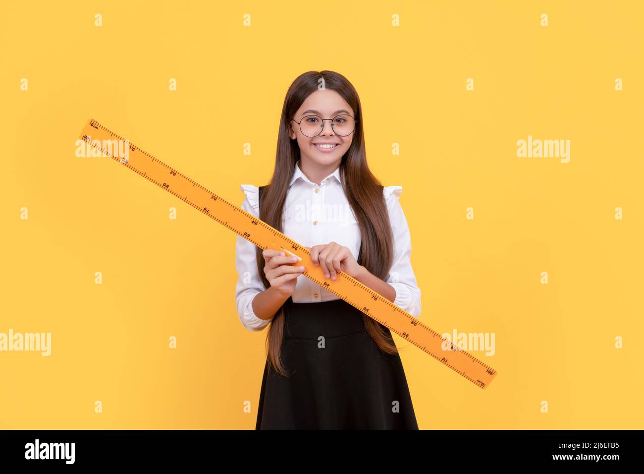 Lächelnd Tween Mädchen halten Lineal. Zurück zur Schule. Algebra und Geometrie. Kind in glassesstudy math Stockfoto