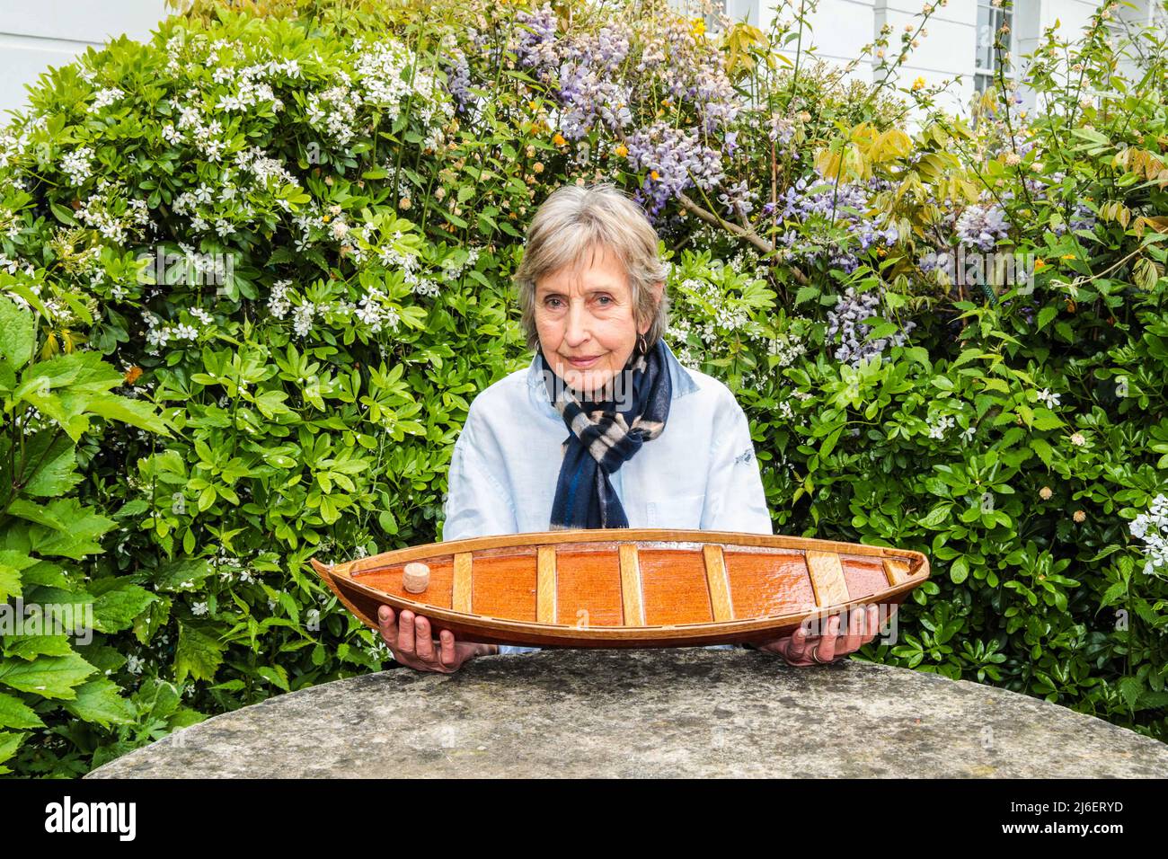 Richmond upon Thames, London Sonntag 1. Mai 2022 Christina Gascoigne (Witwe) mit der Asche ihres verstorbenen Mannes, in einem kleinen Holzboot im Garten in Richmond, wo sie 50 Jahre lang lebten.Quelle: Paul Quezada-Neiman/Alamy Live News Stockfoto