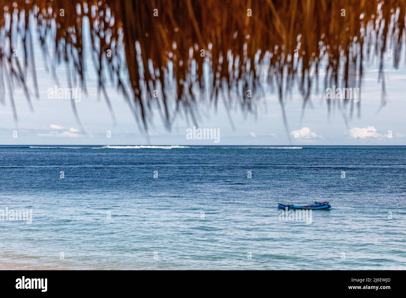 Blick auf das Meer unter dem Strohdach. Tropischer Urlaub. Rote, Ost-Nusa Tenggara, Indonesien. Stockfoto