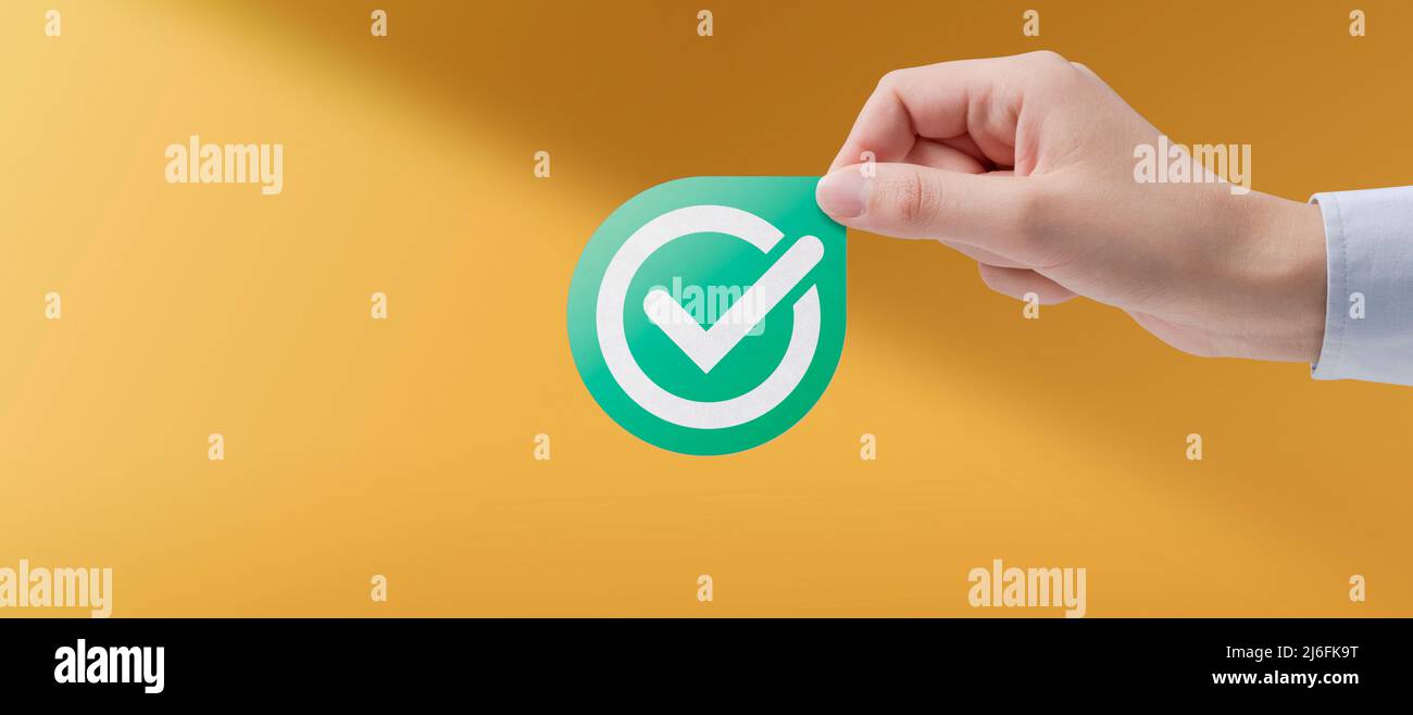 Weibliche Hand mit verifiziertem Abzeichen, Qualitäts- und Optimierungskonzept Stockfoto