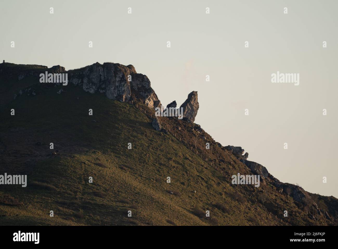 Dramatische Felsvorsprünge auf schottischem Hügel mit zerklüfteten Klippen und Grashängen Stockfoto