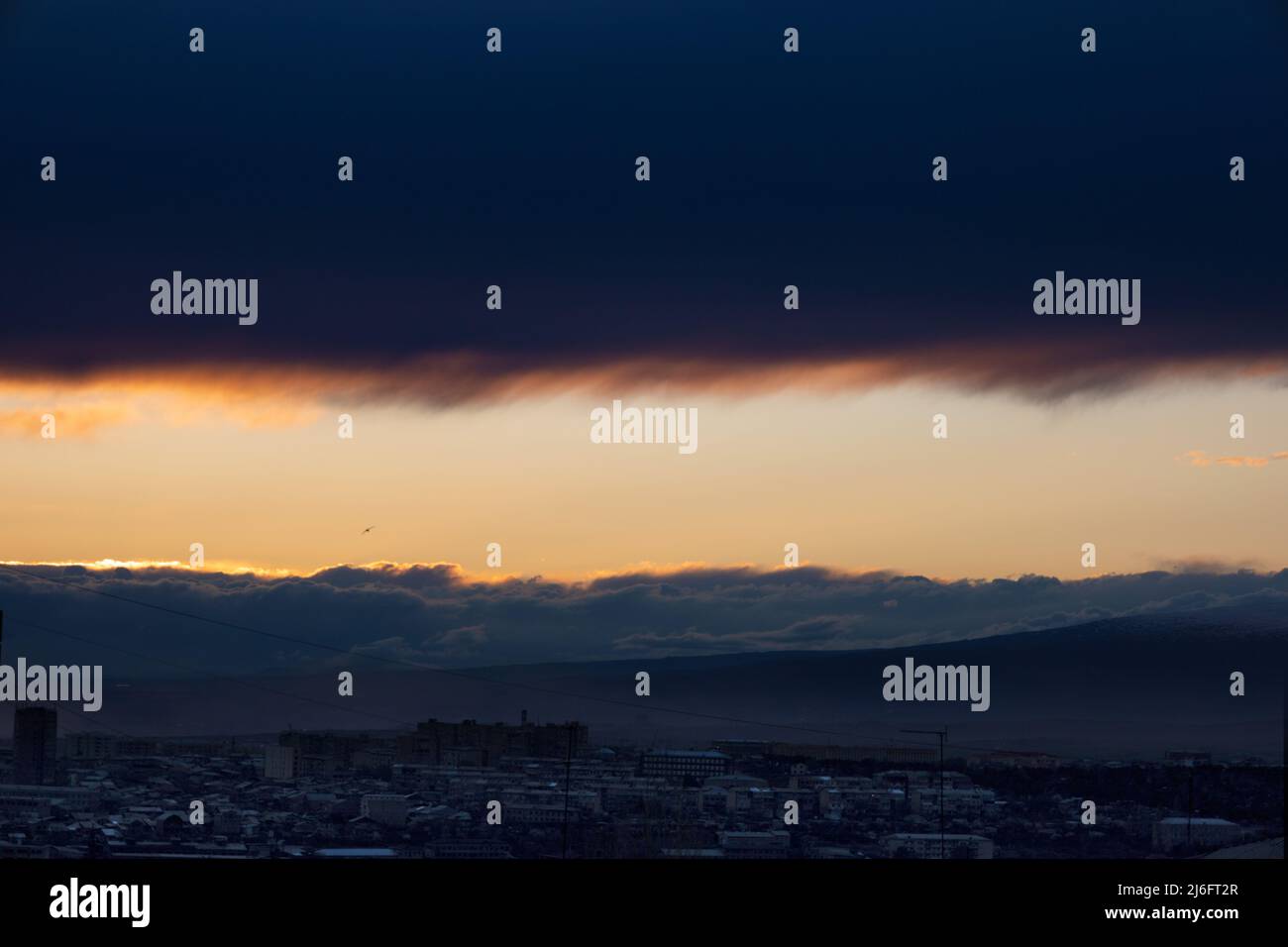 Bunte Wolken über der Stadt bei Sonnenuntergang Stockfoto