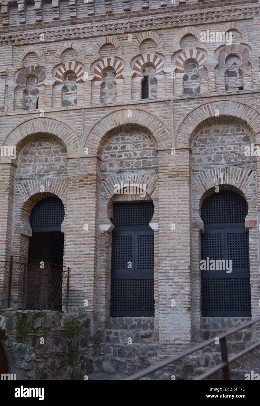 Toledo, Kastilien-La Mancha, Spanien. Schrein von Cristo de la Luz. Ehemalige Moschee, Ende des 10.. Jahrhunderts erbaut und im 12.. Jahrhundert in eine christliche Kirche umgewandelt. Architektonisches Detail der Nordwestfassade. Es ist aus Backstein gebaut und verfügt über drei halbrunde Bögen, die von Hufeisenbögen umrahmt sind, mit Öffnungen, die zum Gebetsraum führen. Der obere Teil besteht aus polygelappten Bögen, die Hufeisenbögen im Stil des Khiphals umrahmt und mit Voussoirs verziert sind. Stockfoto