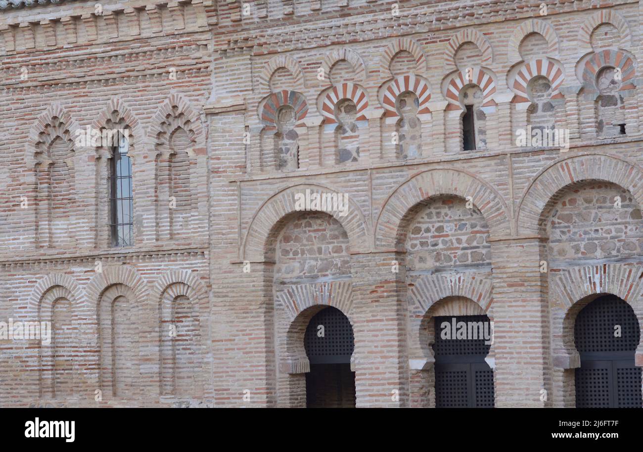 Toledo, Kastilien-La Mancha, Spanien. Schrein von Cristo de la Luz. Ehemalige Moschee, Ende des 10.. Jahrhunderts erbaut und im 12.. Jahrhundert in eine christliche Kirche umgewandelt. Architektonisches Detail der Nordwestfassade. Es ist aus Backstein gebaut und verfügt über drei halbrunde Bögen, die von Hufeisenbögen umrahmt sind, mit Öffnungen, die zum Gebetsraum führen. Der obere Teil besteht aus polygelappten Bögen, die Hufeisenbögen im Stil des Khiphals umrahmt und mit Voussoirs verziert sind. Stockfoto