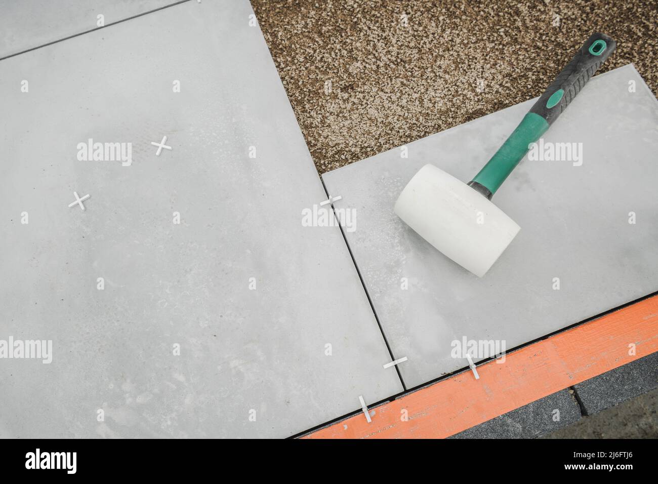 Soft Gum Made Hammer Laying auf Beton Terrasse Boden Blöcke. Bodenbelag Auf Der Terrasse Im Hinterhof. Stockfoto
