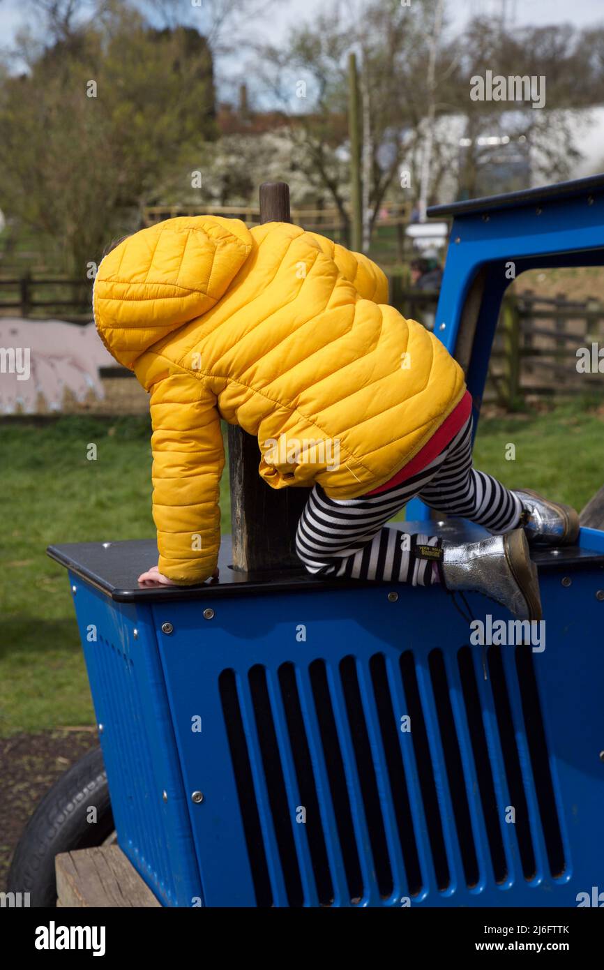 Kinder klettern auf einem blauen Traktor. Stockfoto