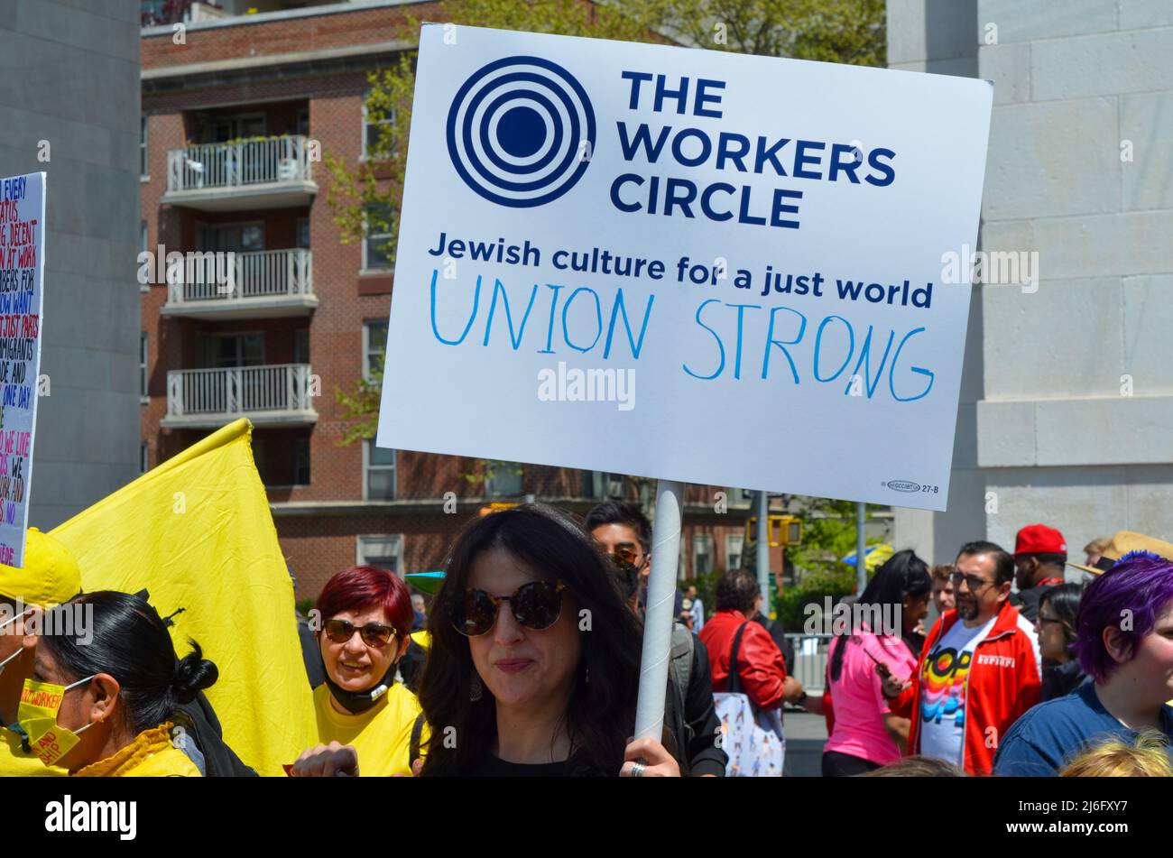 A Workers Holds Sign forderte am 1. Mai 2022 während der Parade am Washington Square Park in New York City einen stärkeren Schutz der Arbeiter. Stockfoto
