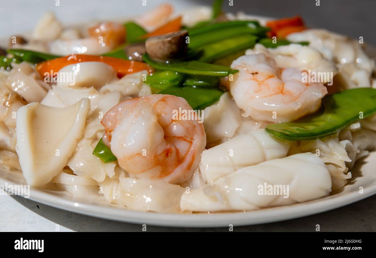 Ein Gericht mit gebratenen Meeresfrüchten mit Reisnudeln oder Ho Fun mit Sauce. Stockfoto