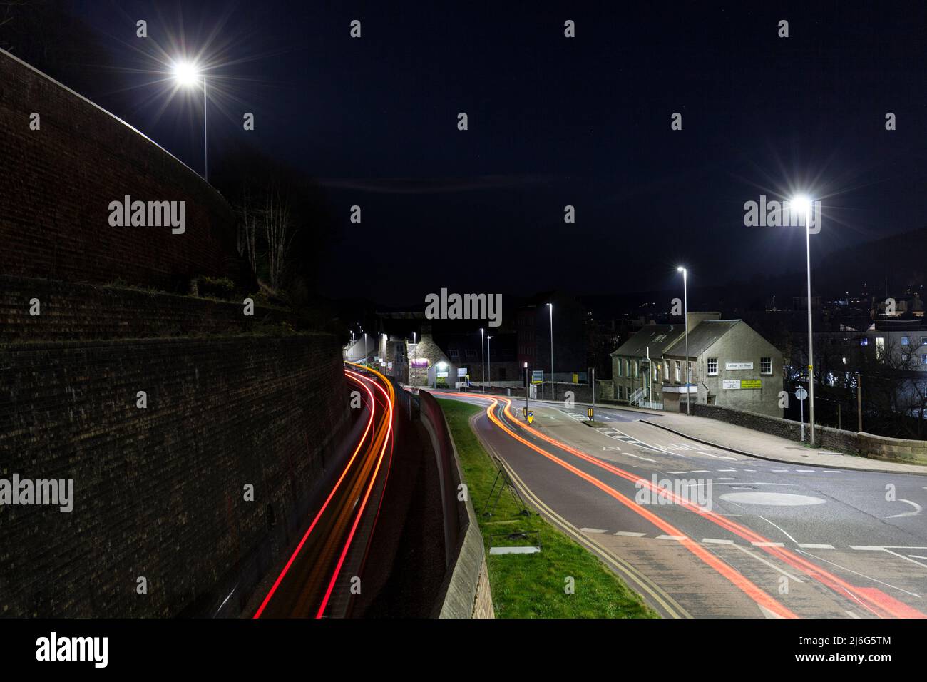 Leichte Wege auf der Straße und Bahnlinie im Stadtzentrum von Galashiels, nachts, Scottish Borders, Großbritannien Stockfoto