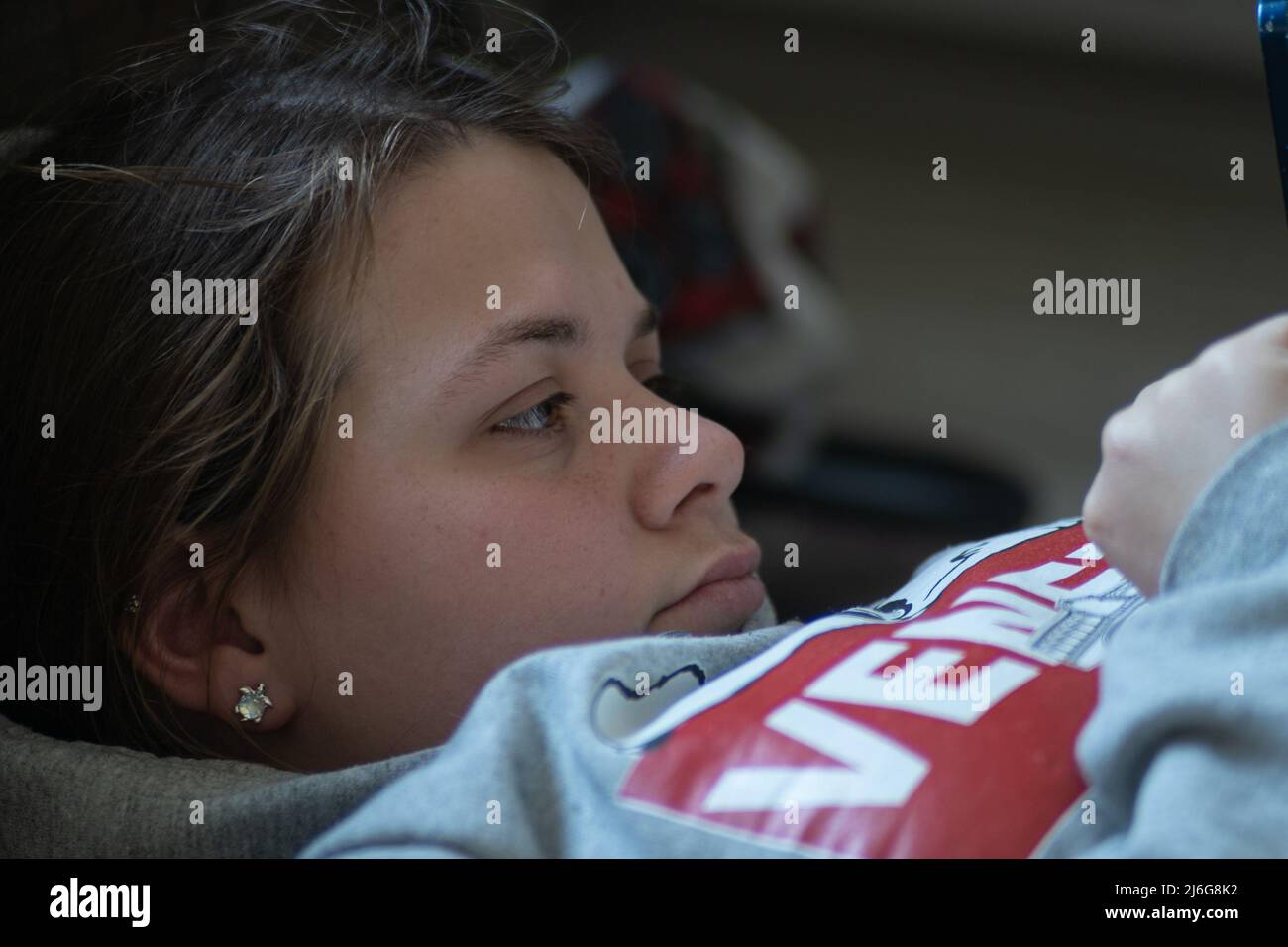 Junge Frau/Mädchen, die ein Video oder einen Film auf einem Mobiltelefon streamen Stockfoto