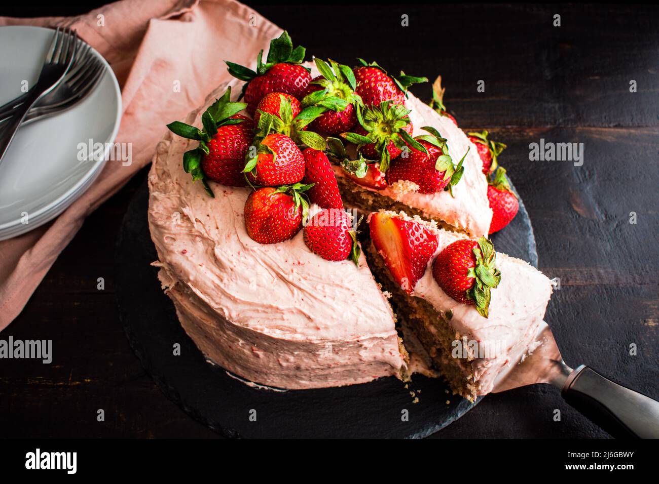 Erdbeerkuchen in Scheiben mit frischen Erdbeeren: Blick von oben auf frischen Erdbeerkuchen mit Frischkäse-Zuckerguss Stockfoto