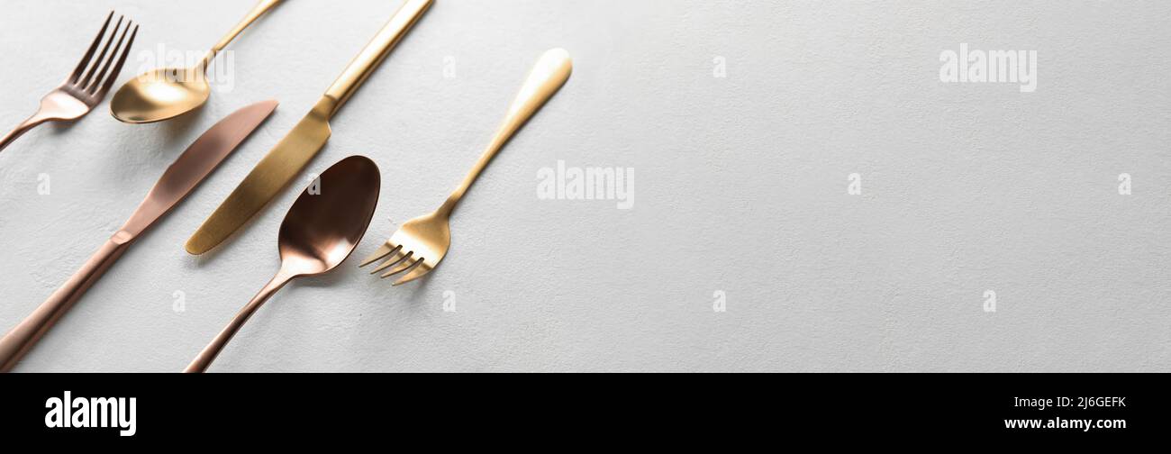 Gabeln, Messer und Löffel auf hellem Hintergrund mit Platz für Text Stockfoto
