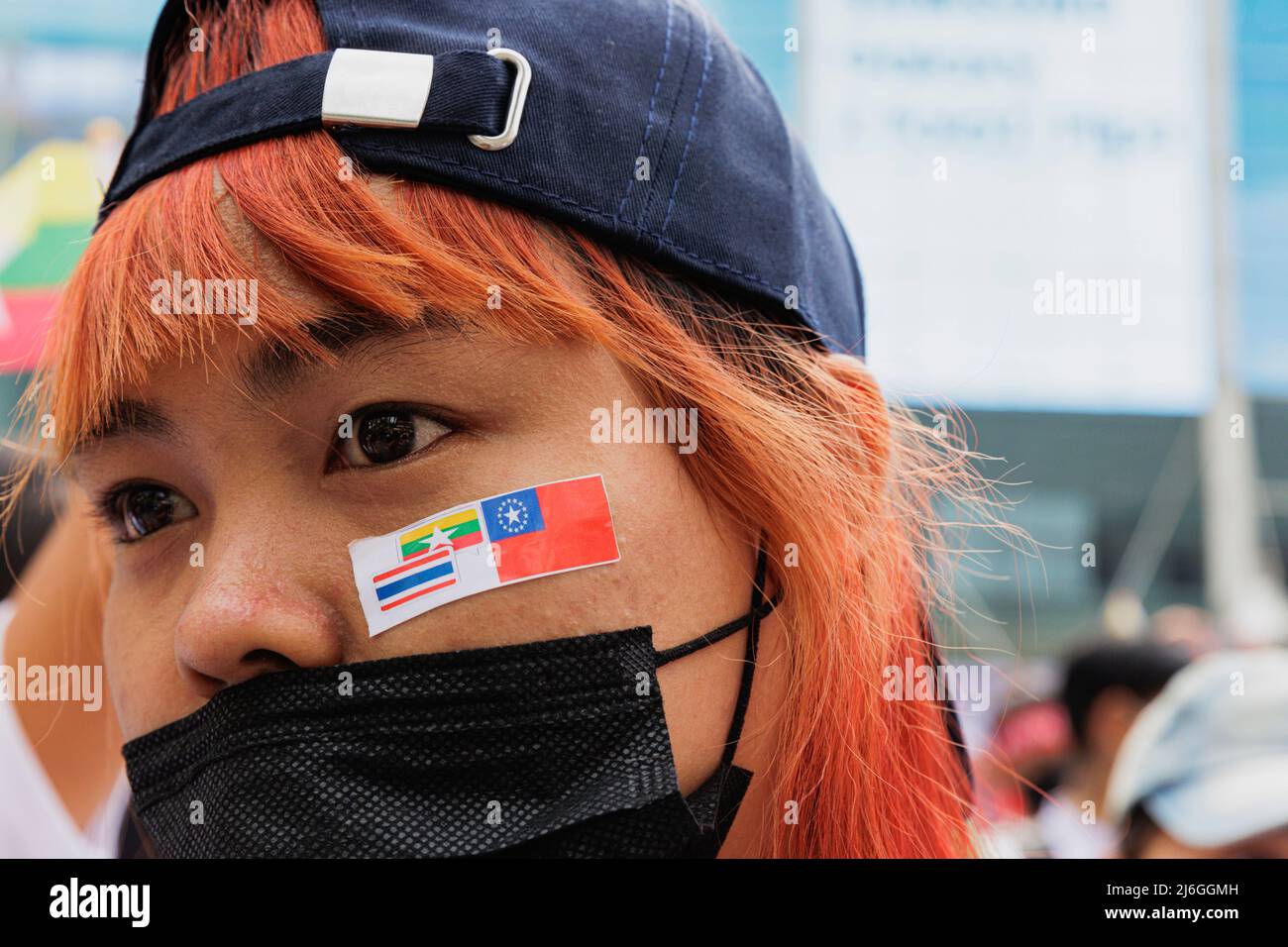 Während der Demonstration wurde die in Myanmar geplate Demonstratorin mit einem Aufkleber im Gesicht gesehen. Die Arbeitergewerkschaft veranstaltete am Tag der Arbeit in Bangkok, Thailand, eine Parade. An der Parade nahmen verschiedene Gruppen Teil, darunter die thailändische Arbeitergruppe, die myanmarische Arbeitergruppe und die pro-demokratische Gruppe. Sie versammelten sich an der Ratchaprosong Road und marschierten dann zur Kreuzung Pathumwan, Demonstranten forderten Wohlfahrt, faire Zinszahlungen und auch Demokratie (einschließlich Thailand und Myanmar). Stockfoto