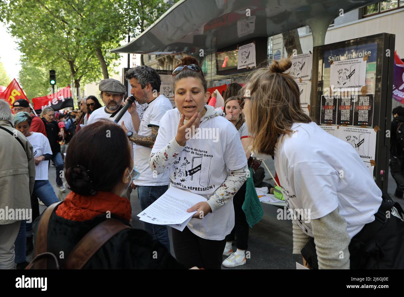 Politische Unterstützer nehmen während der Demonstration Flugblätter und Broschüren vom Parteistand. Tausende Demonstranten nahmen am 1.. Mai, dem Internationalen Arbeitertag, an der Parade zum 1. Mai in Paris Teil. Der Marsch begann vom Platz der Republik zum Platz der Nation. Stockfoto