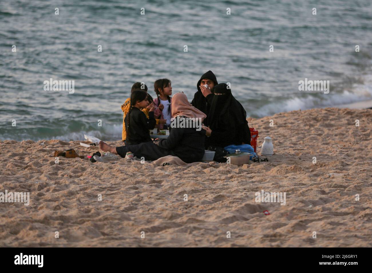 Die palästinensische Familie bricht ihr Fasten mit iftar am letzten Tag des heiligen Monats Ramadan am Ufer des Mittelmeers in Gaza-Stadt. Stockfoto