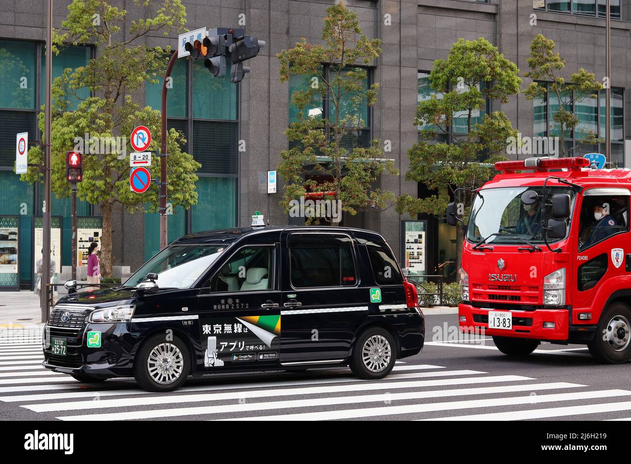 TOKIO, JAPAN - 23. April 2022: Ein Taxi und ein Feuerwehrmotor auf einer Straße im Tokioter Stadtteil Otemachi. Stockfoto