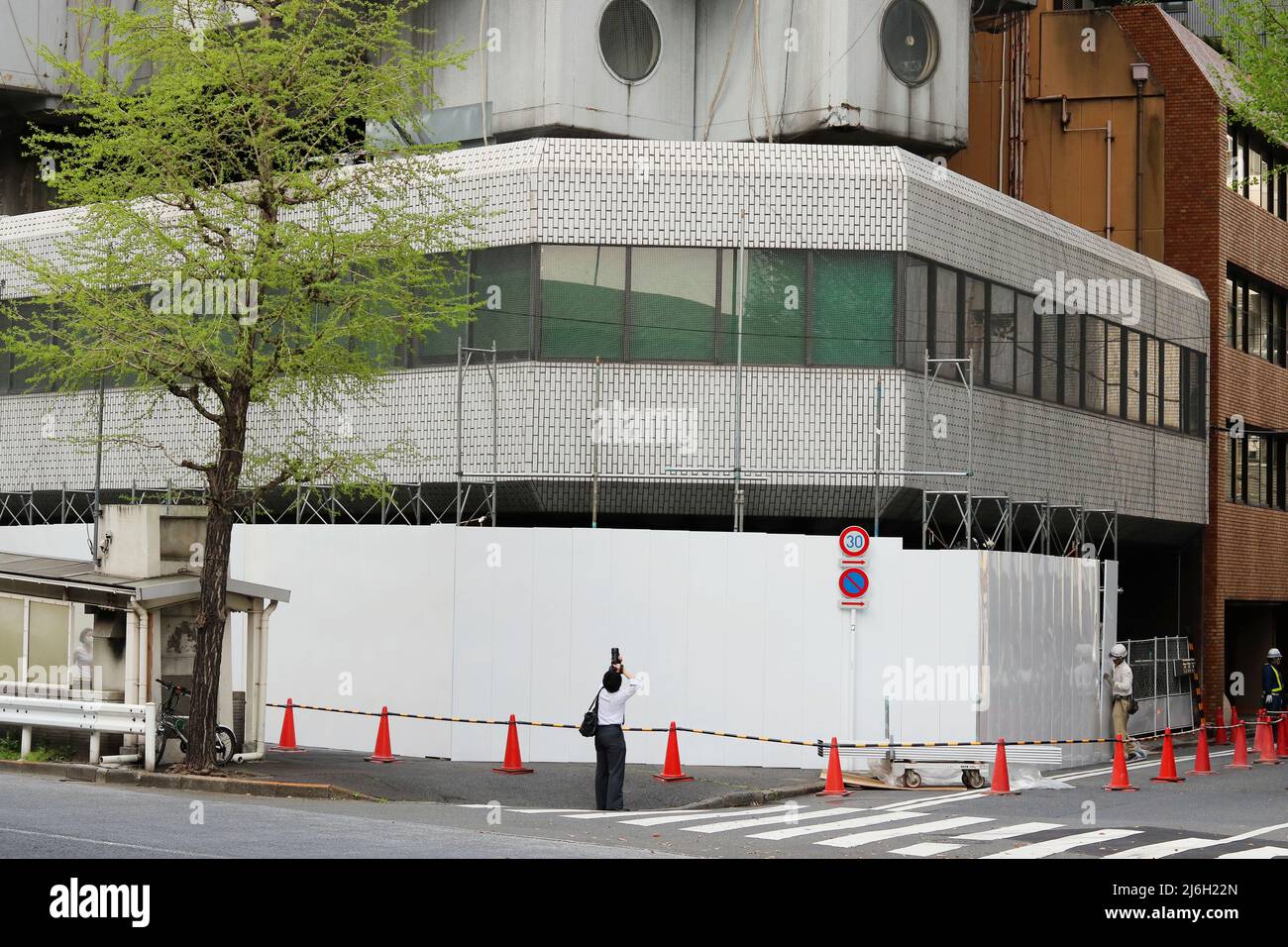 TOKIO, JAPAN - 13. April 2022: Menschen fotografieren den Nakagin-Kapselturm, der gerade abgerissen wird. Stockfoto
