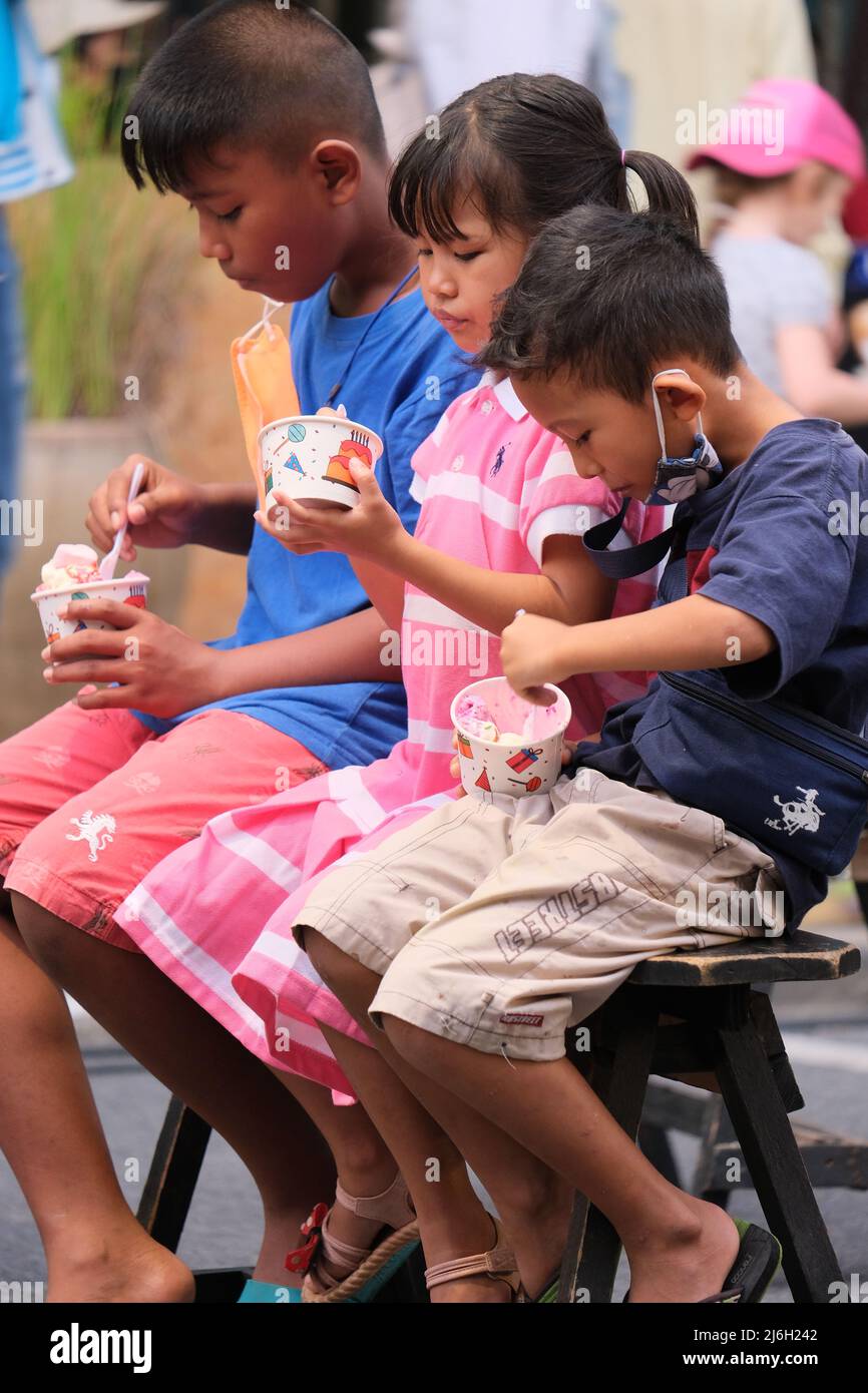 Phuket Thailand - November 21 2021: Kinder sind damit beschäftigt, auf einem Straßenmarkt buntes Eis zu essen Stockfoto