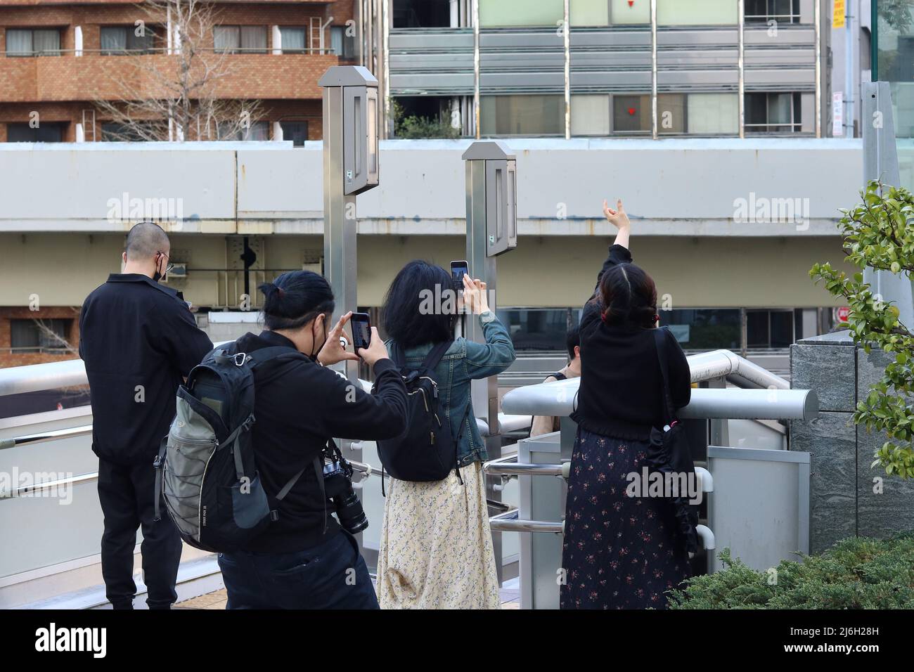 TOKIO, JAPAN - 9. April 2022: Menschen fotografieren den Nakagin Capsule Tower in Tokyos Ginza-Gegend, bevor er abgerissen werden soll. Stockfoto
