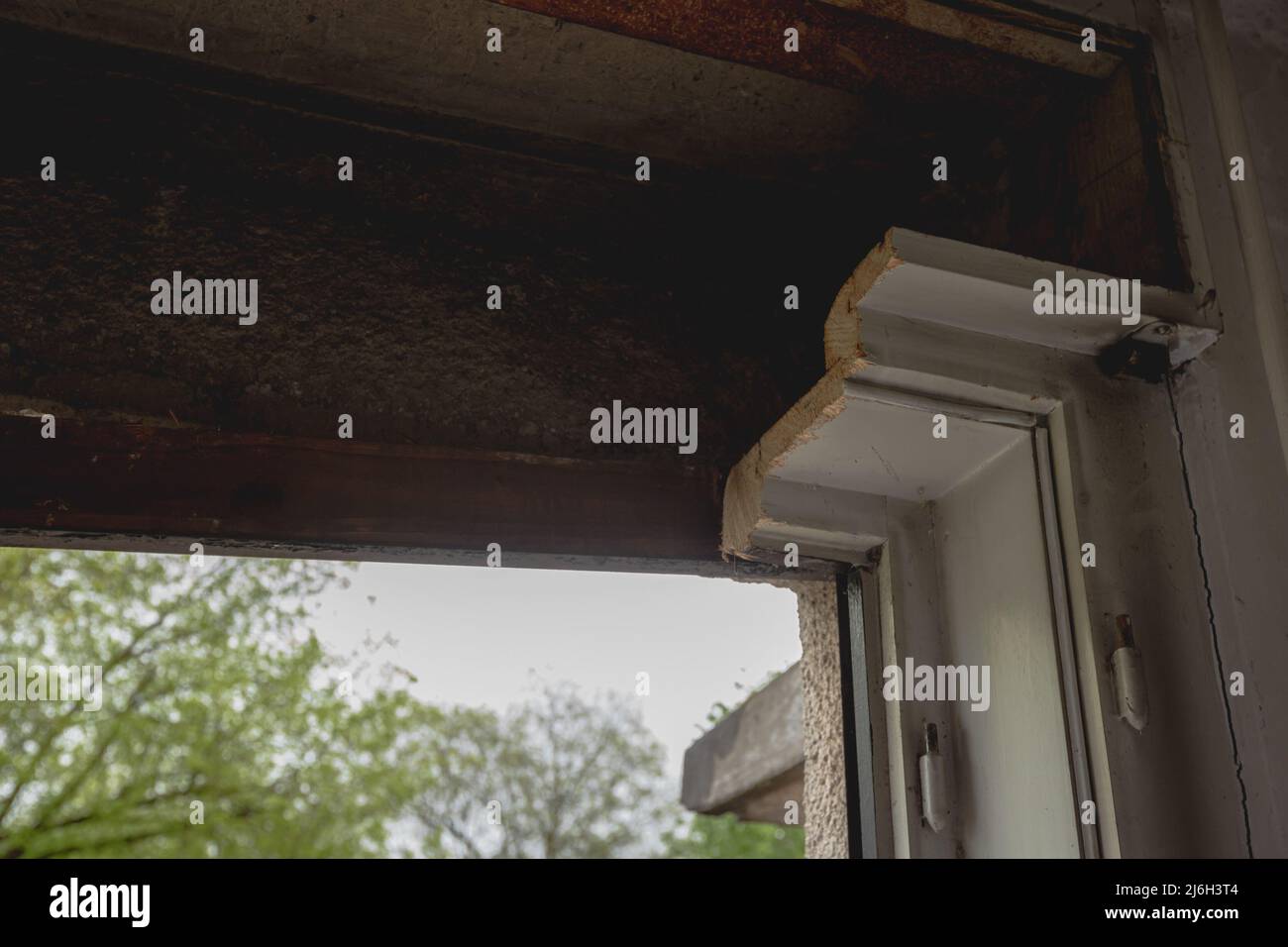 Alte Holzfenster, die aus einem alten Haus herausgeschnitten wurden, machen Platz, um moderne dreischichtige Isolierfenster zu installieren. Sichtbares Profil des alten Holzrahmens Stockfoto