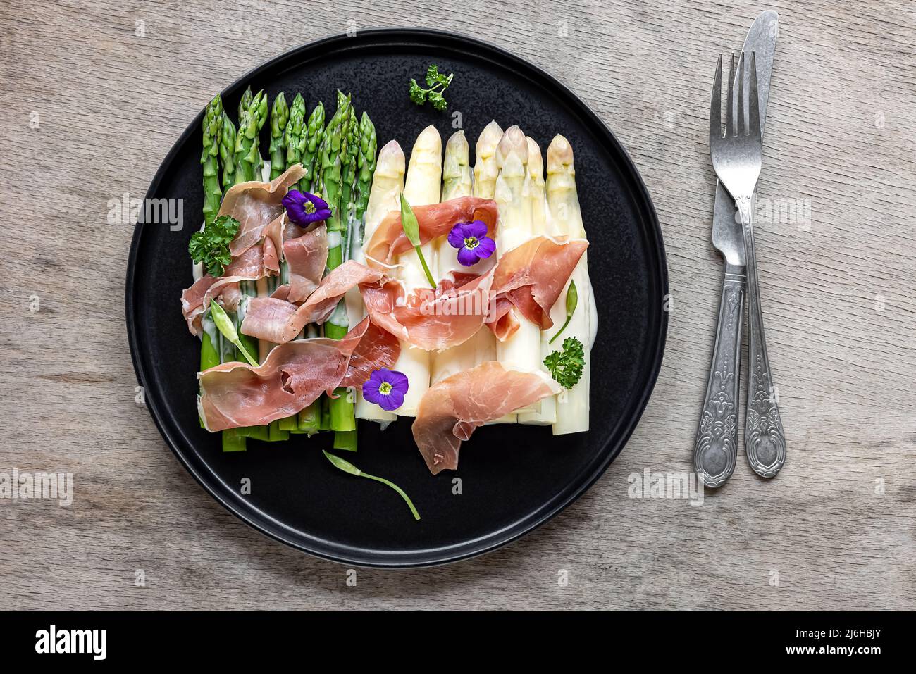 Weißer und grüner Spargel mit Schinken. Stockfoto