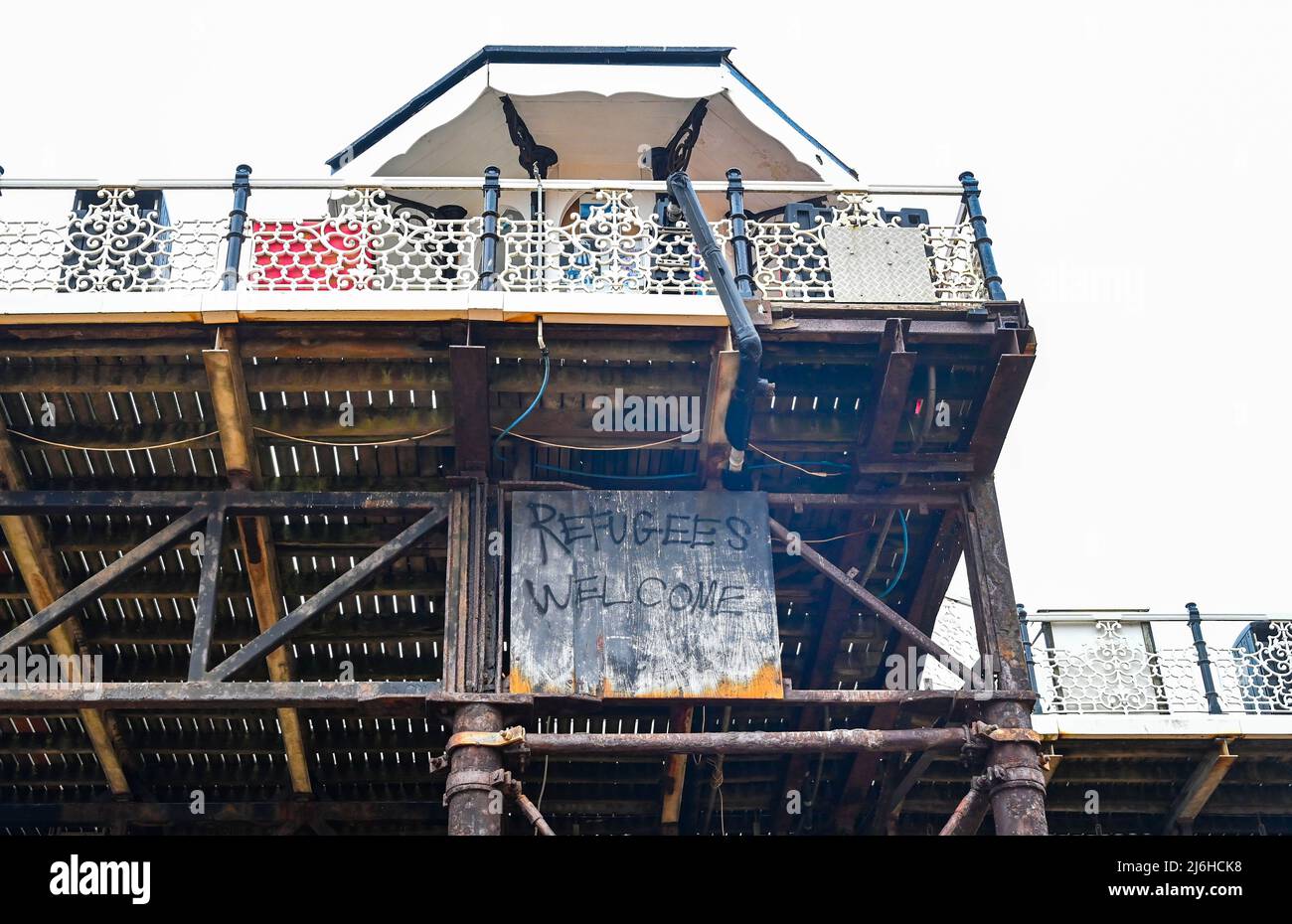Brighton UK 2. May 2022 - Ein Flüchtlingsschild unter dem Brighton Palace Pier an einem trüben, bewölkten Maifeiertag : Credit Simon Dack / Alamy Live News Stockfoto