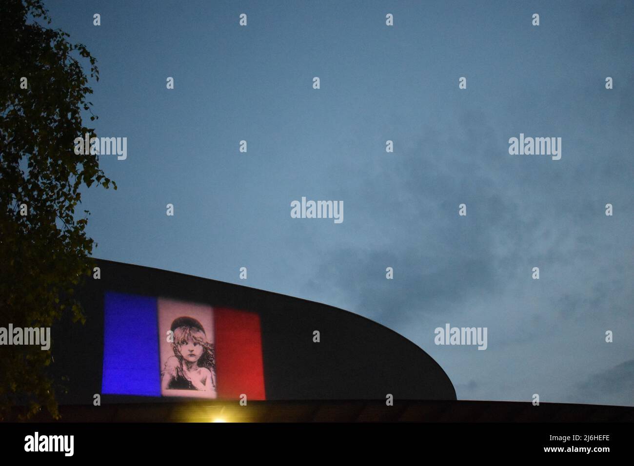 Die Flagge von Les Misérables wird auf der Seite des Milton Keynes Theaters mit Copyspace projiziert. Stockfoto