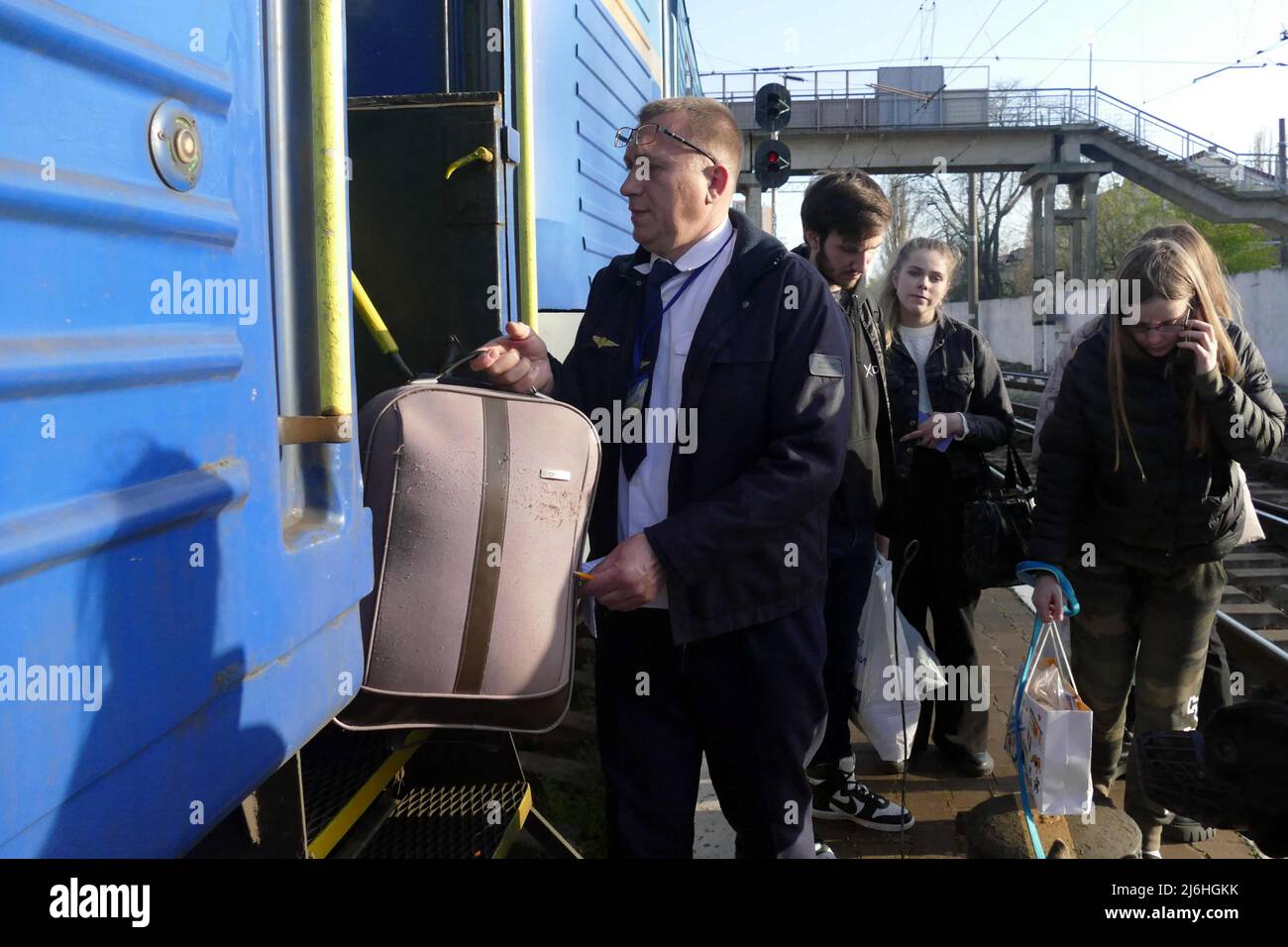 ODESA, UKRAINE - 25. APRIL 2022 - Ein Mann hilft einem Passagier mit einem Koffer vor dem Abflug eines Evakuierungszuges, der Menschen auf der Flucht bringen wird Stockfoto