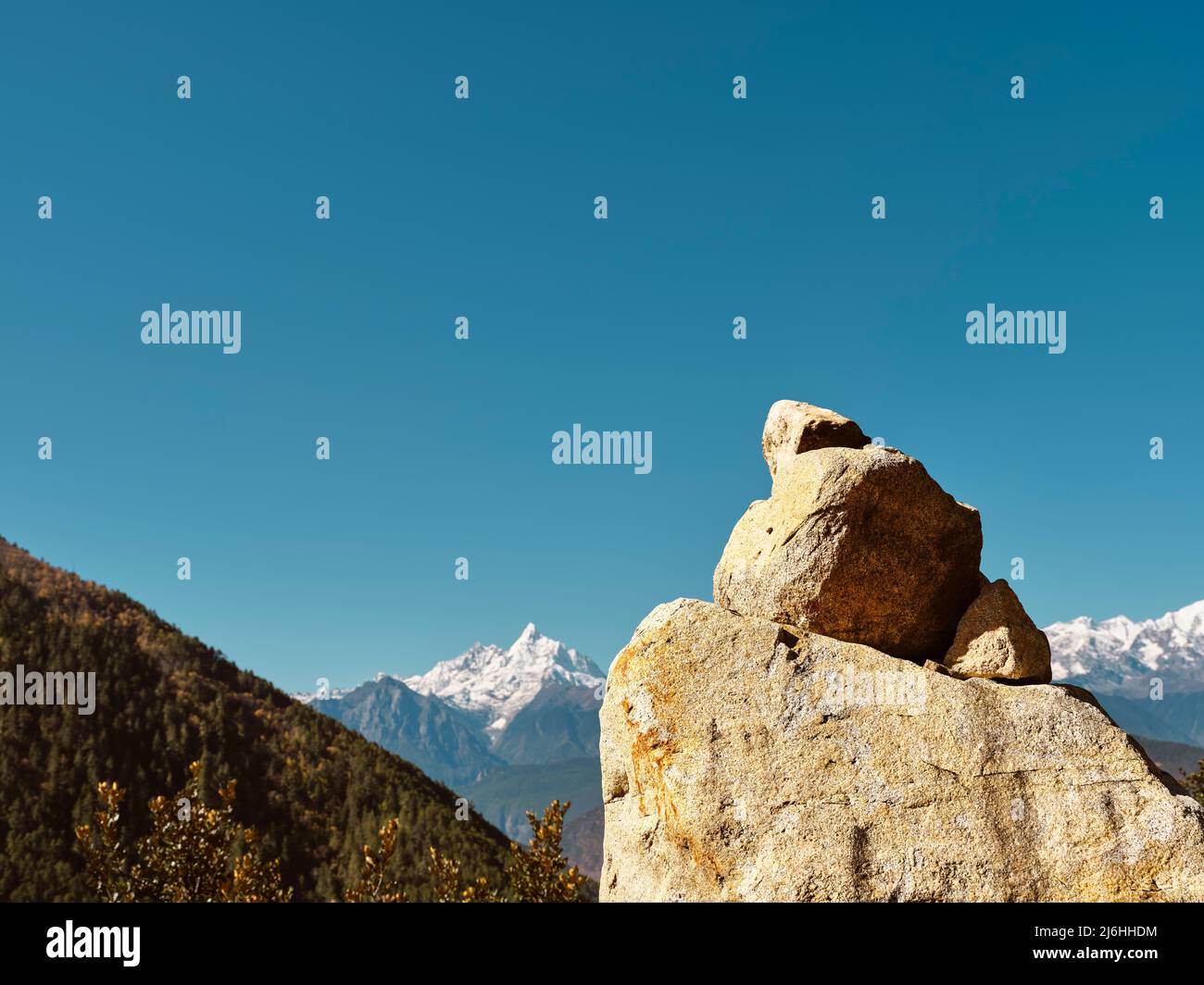 Riesige Gebetssteine unter blauem Himmel mit schneebedeckter meili-Bergkette im Hintergrund, sichuan, china Stockfoto