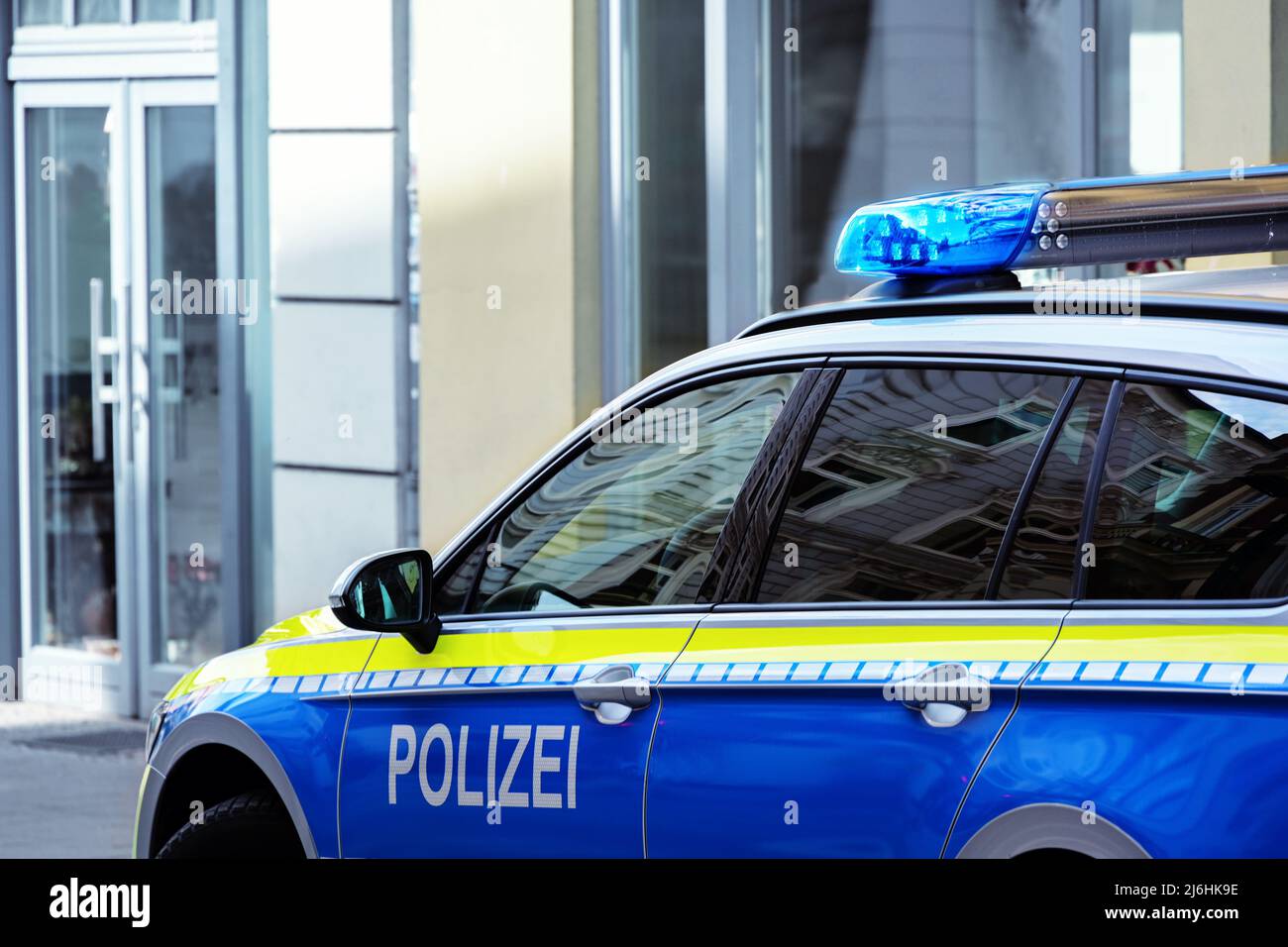 Teil eines Polizeiwagens mit blauem Licht auf einer Stadtstraße, Kopierbereich, ausgewählter Fokus, enge Schärfentiefe Stockfoto