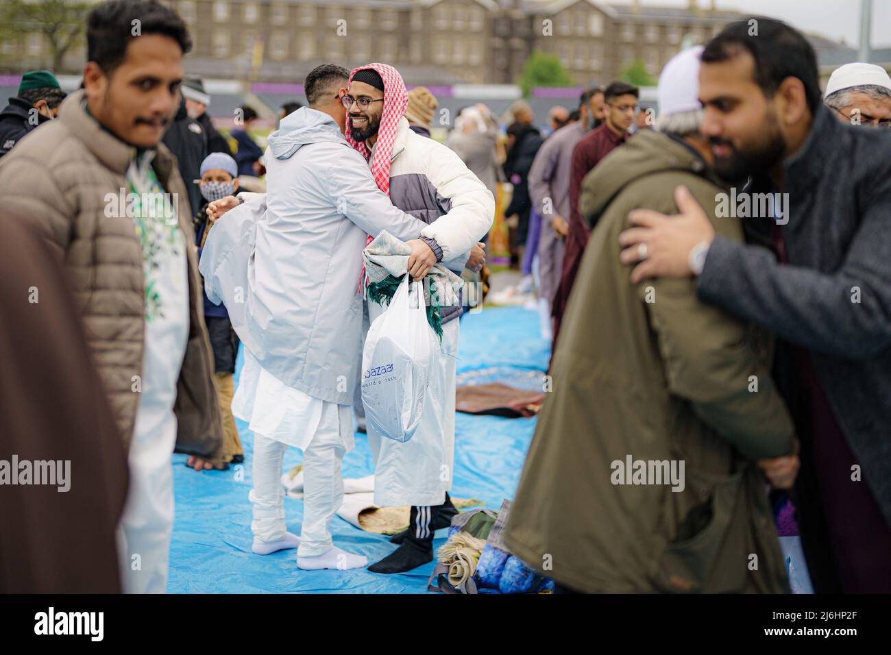 Die Menschen umarmen und grüßen sich nach dem Eid-Gebet während der Sunnah, während sie im Freien im Big Eid Salah in Bristol beten: Eid al-Fitr 2022, als der heilige Monat Ramadan zu Ende geht und Muslime Eid al-Fitr feiern. Bilddatum: Montag, 2. Mai 2022. Stockfoto