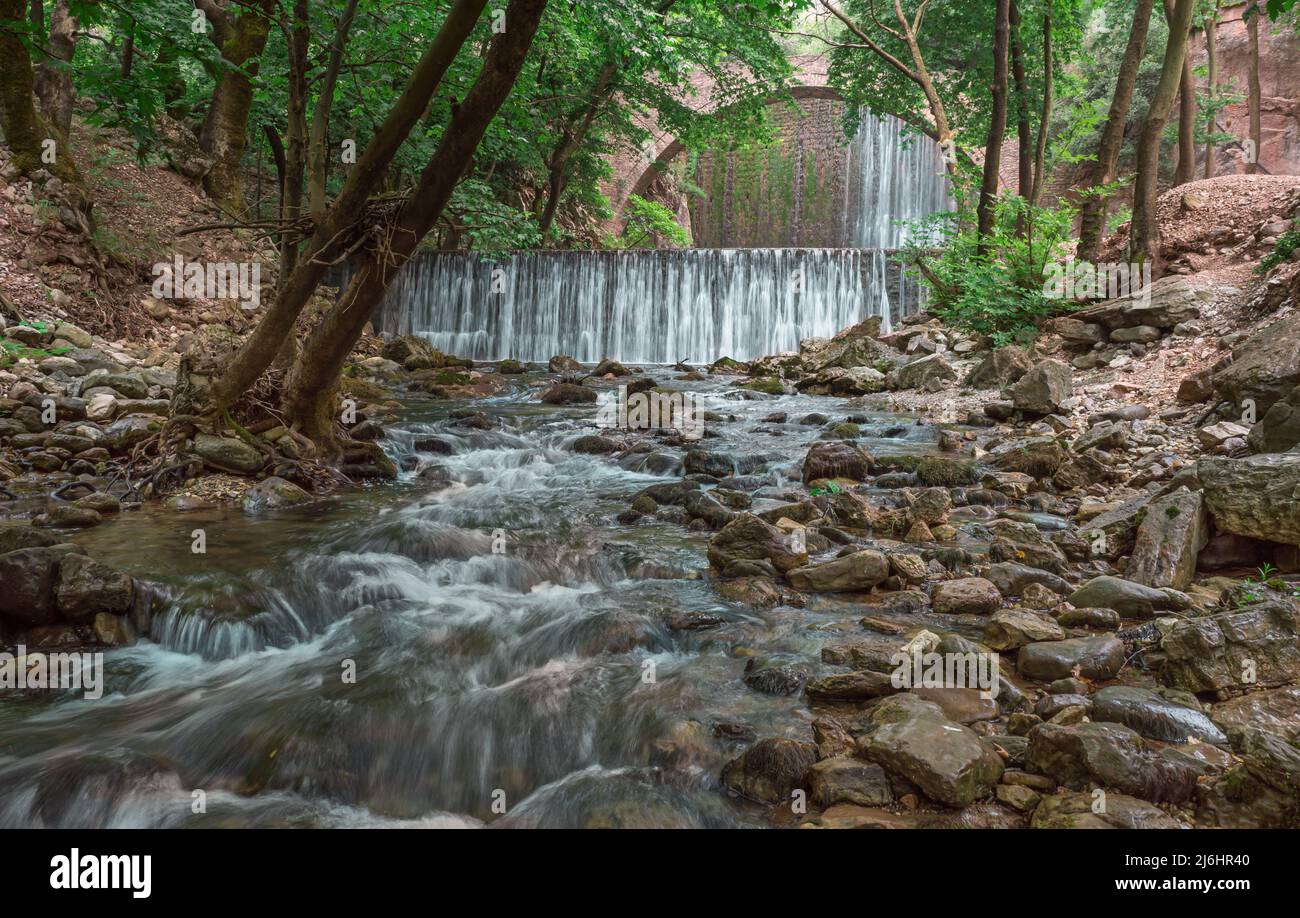 Die alte, gewölbte Steinbrücke zwischen zwei Wasserfällen in Palaiokaria, Präfektur Trikala, Thessalien, Griechenland. Stockfoto