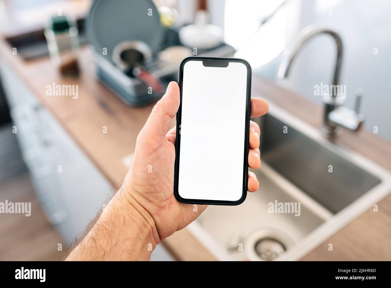 Smart-Home-Smartphone-Mockup-Bildschirm vor dem Spülbecken, selektiver Fokus Stockfoto