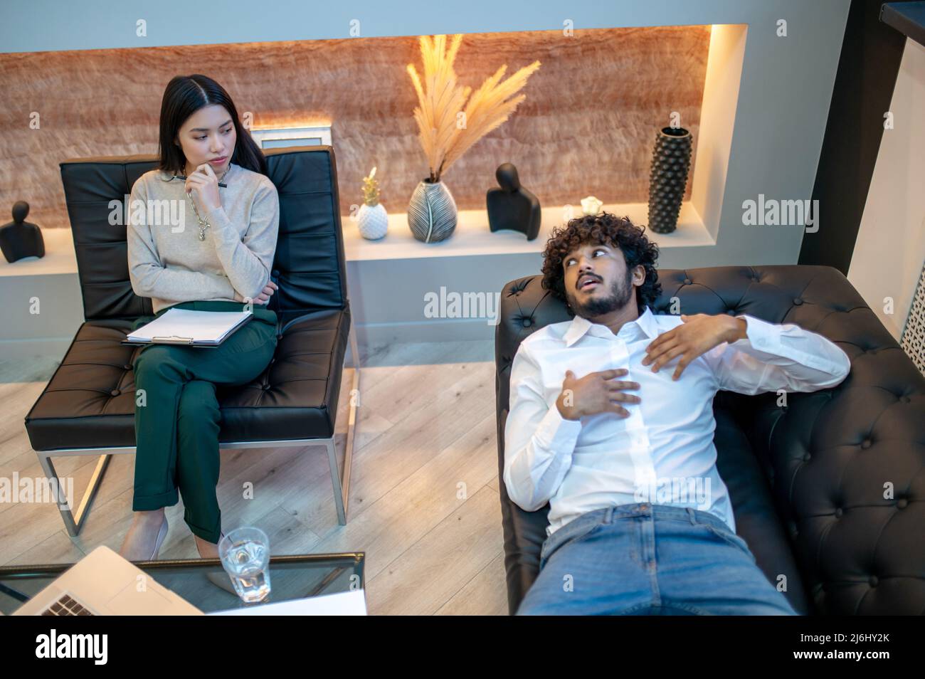 Notleidende junge männliche Patientin, die sich der Psychotherapie unterziehen muss Stockfoto