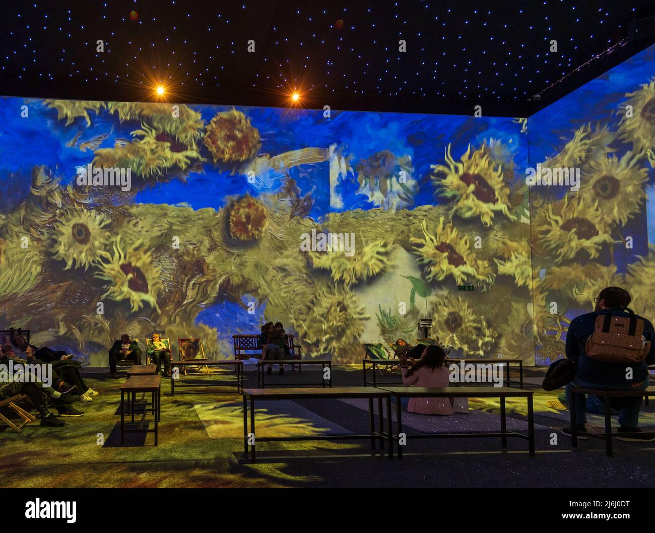 London, Großbritannien. 30. April 2022. Zuschauer beobachten Sunflowers-Serie bei Van Gogh The Immersive Experience mit illustrierten Licht- und Klanggeschichten. Stockfoto