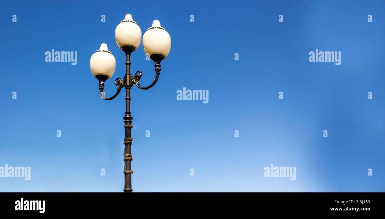 Drei runde weiße Laternen vor einem klaren blauen Himmel. Stockfoto