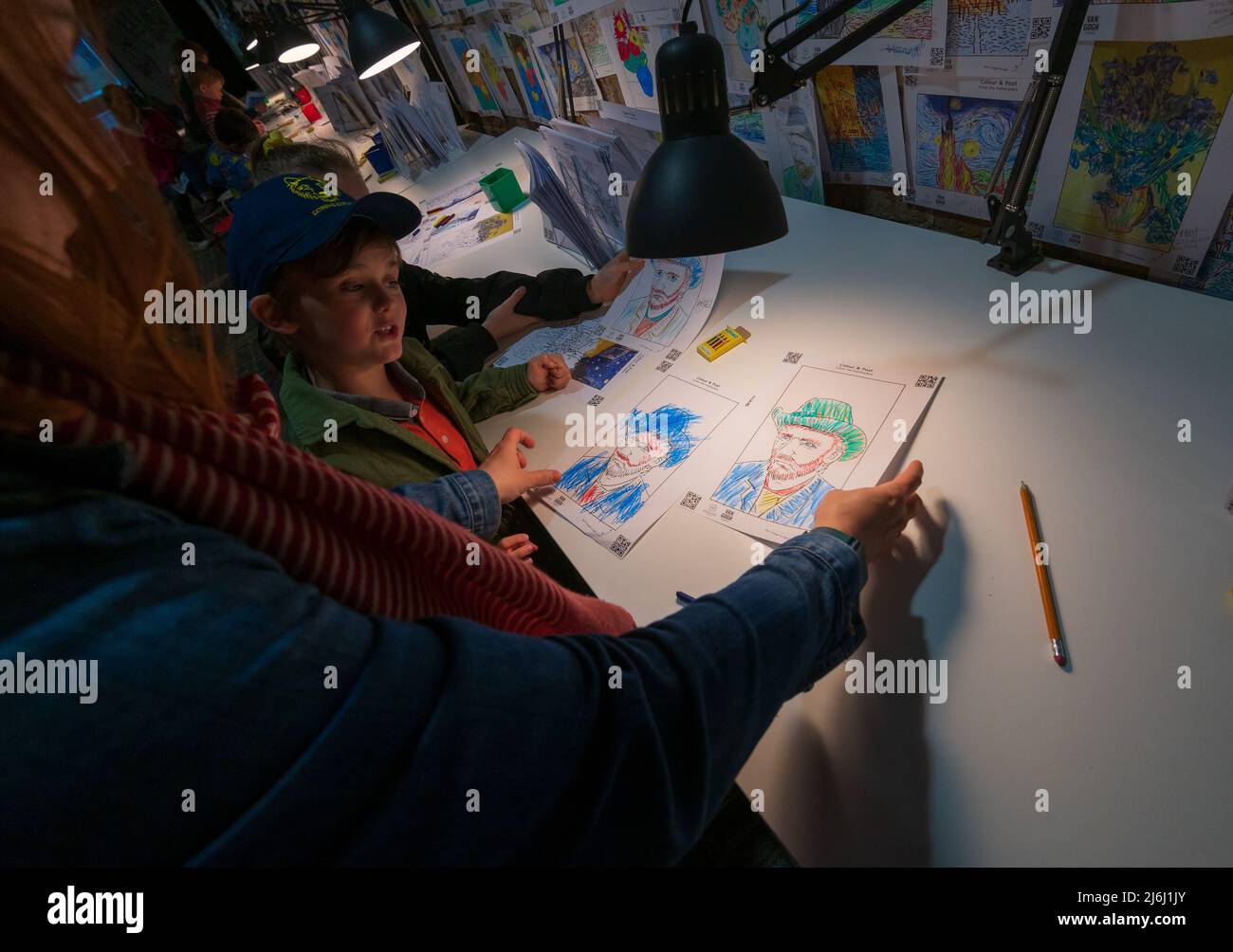 London Shoreditch, Großbritannien. 30. April 2022. Eltern mit Kindern malen einen Druck bei Van Gogh die Immersive Experience Ausstellung. Stockfoto